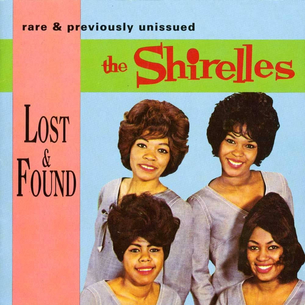 The Shirelles《The Definitive Collection》專輯封面 壁紙 — 四位面帶微笑、擁有1960年代豐盈髮型的女性，在粉彩背景前擺姿勢，背景上有粗體文字寫著「the Shirelles」和「Lost & Found」。
