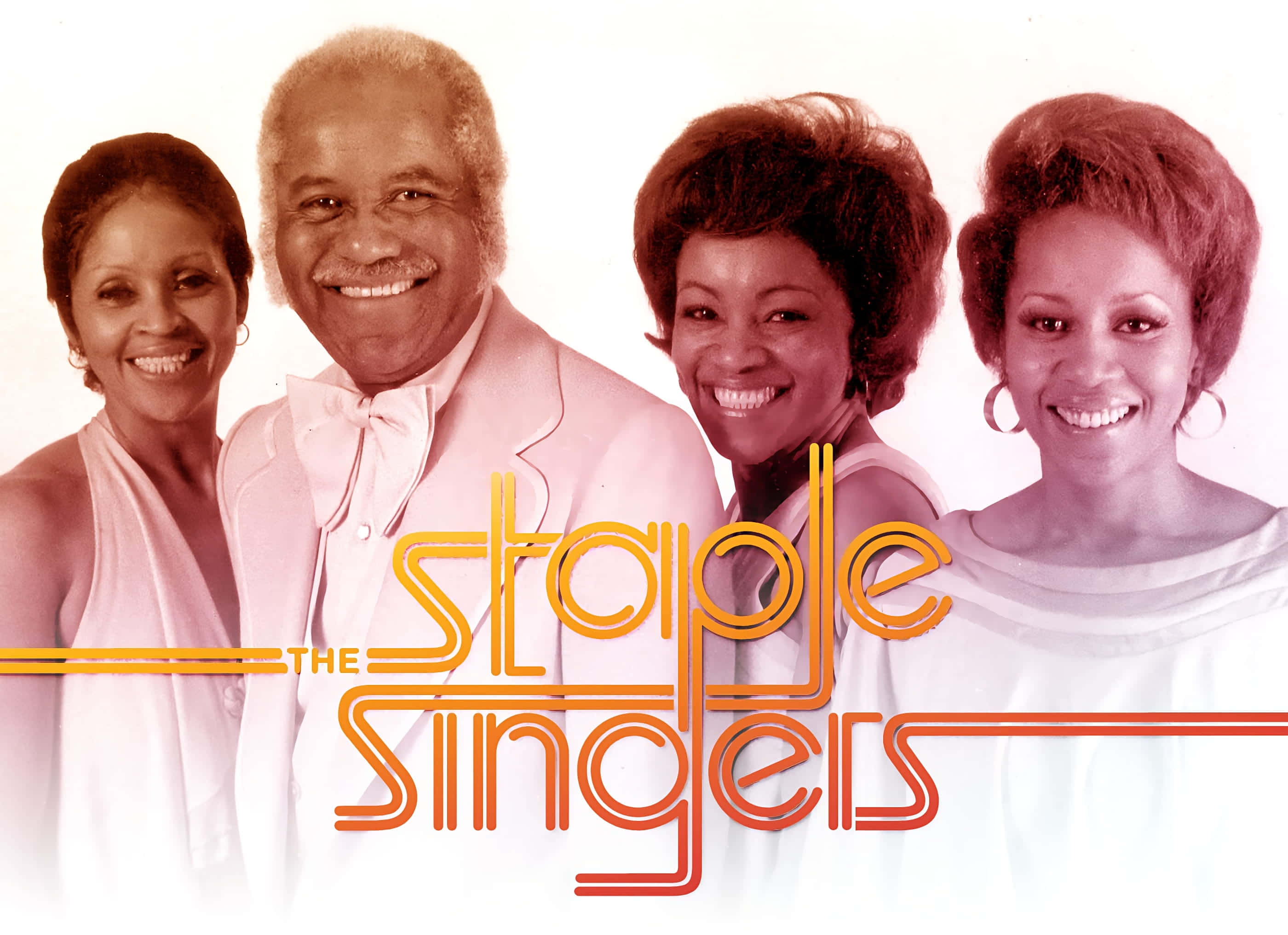 美國福音音樂傳奇：The Staple Singers 壁紙 — The Staple Singers 的四位微笑成員穿著復古粉紅和白色服裝，在純色背景前擺姿勢，並帶有風格化的橙色文字。