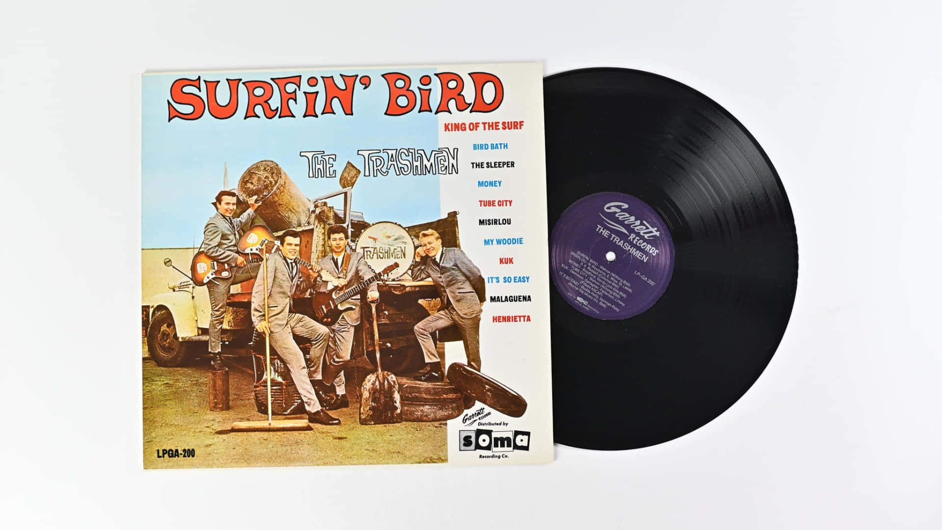  壁紙 — The Trashmen 的 'Surfin' Bird' 復古衝浪搖滾專輯封面，旁邊有一張黑色黑膠唱片，背景為白色。