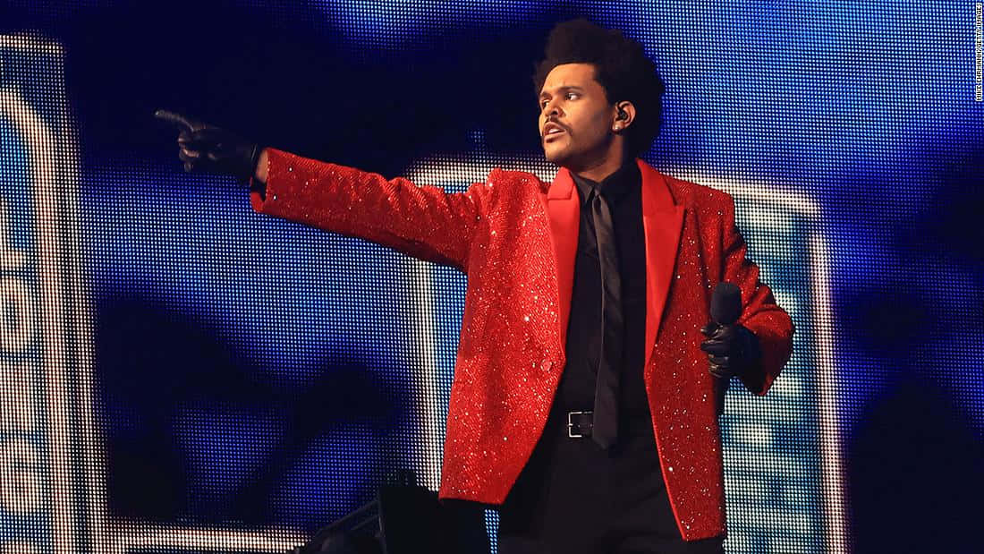 Red Coat 桌布 壁紙 — The Weeknd 喺藍色像素背景前著住閃亮紅色西裝外套表演。