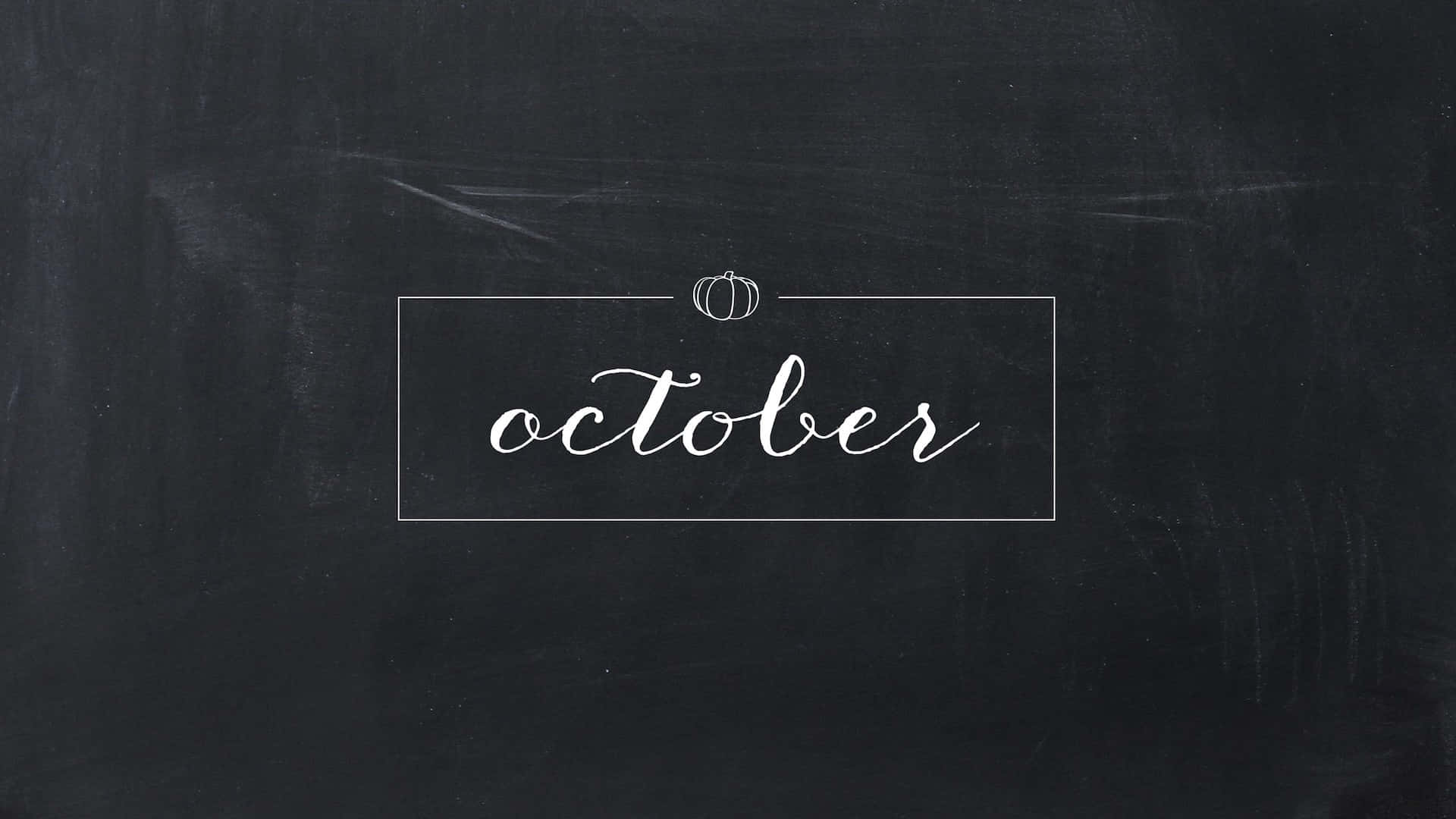 October Desktop 桌布 壁紙 — 「十月」呢個詞用優雅嘅白色草書寫喺一個薄矩形入面，喺有紋理嘅黑色黑板上面，上面有一個細南瓜。