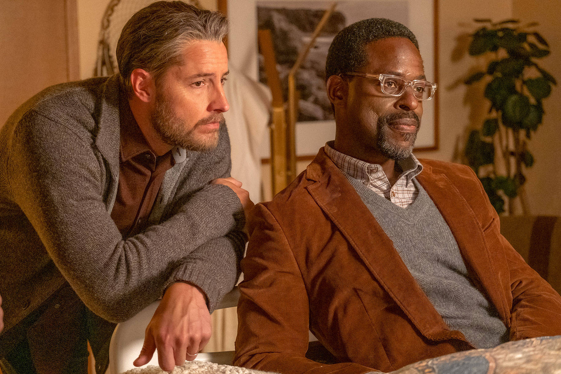 《This Is US》蘭道爾與傑克 壁紙 — 兩個男人在一個溫暖照明的房間裡，一個穿著棕色西裝外套坐著，另一個向前傾，兩人都表情嚴肅。