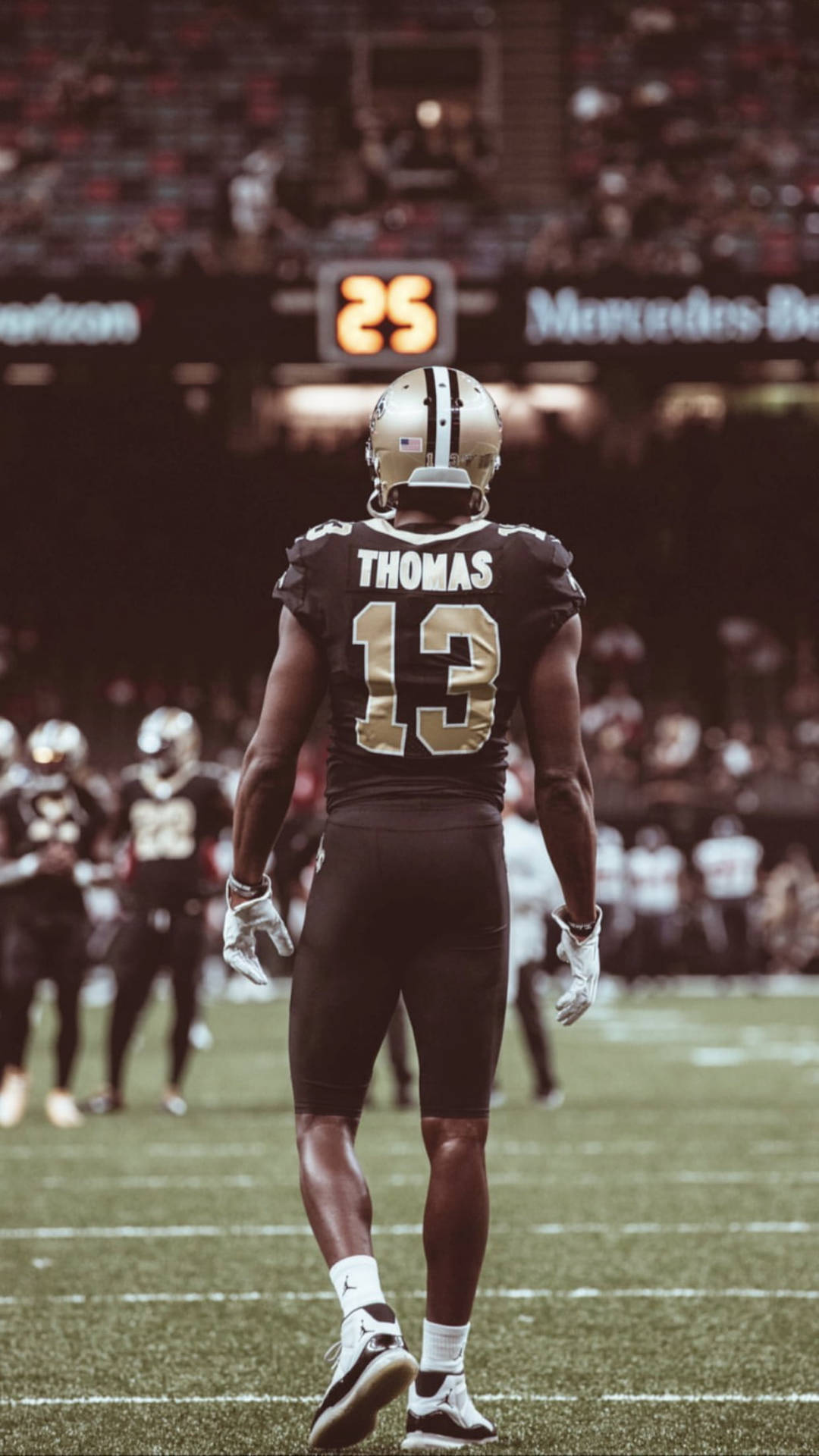 美式足球員Thomas（13號）在比賽中站在球場上。