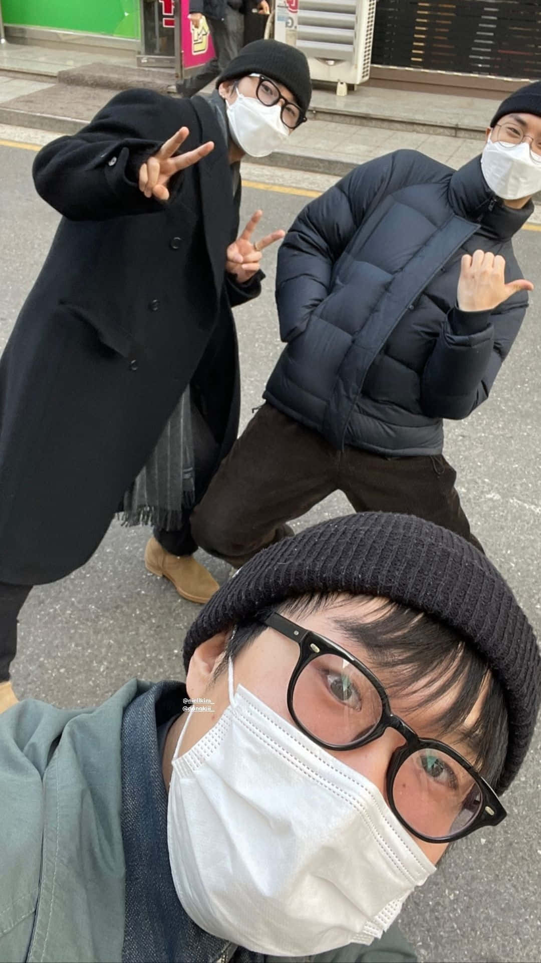 壁紙 — 三位戴著冷帽和眼鏡的蒙面朋友在城市行人路上俏皮地擺姿勢自拍。