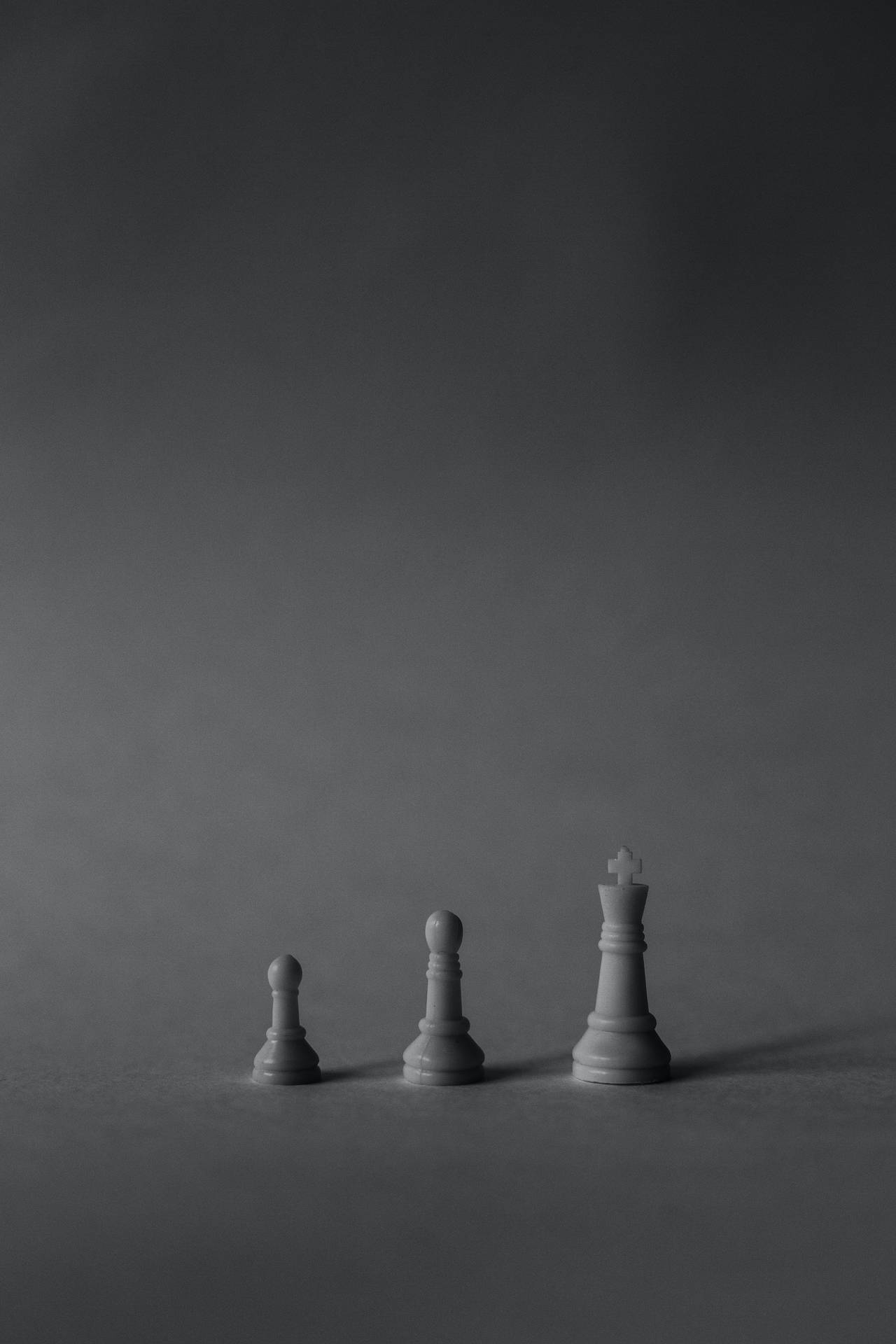 三枚遞增尺寸的國際象棋棋子，灰階工作室照片