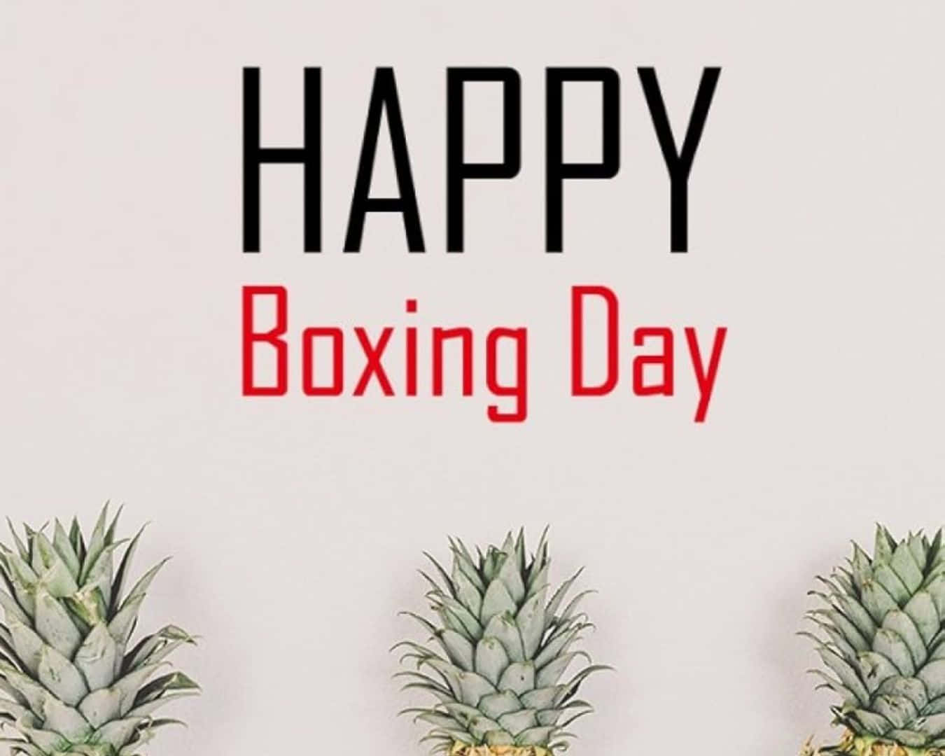  壁紙 — 三個菠蘿位於粗體黑色和紅色的「HAPPY Boxing Day」文字下方，背景為純色米白色。