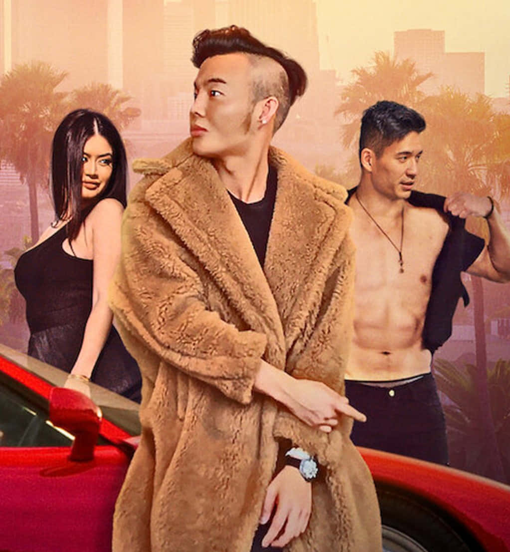 Bling Empire 桌布 壁紙 — 三位穿著時尚的人士自信地在紅色跑車旁擺姿勢，背景是朦朧的城市景觀和棕櫚樹。