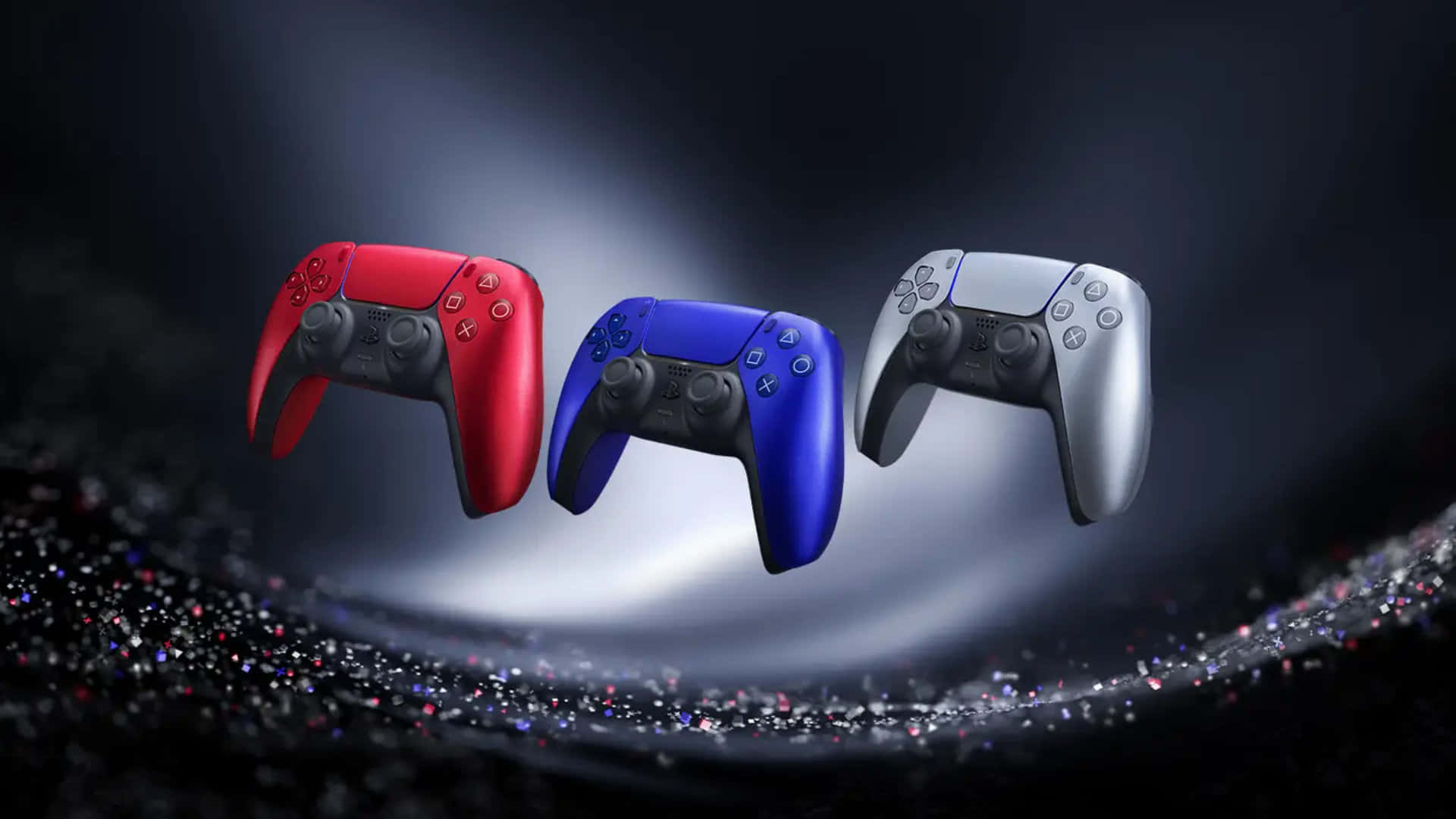  壁紙 — 三個充滿活力的PlayStation 5控制器在戲劇性的聚光燈下漂浮在閃閃發光的黑暗表面上。