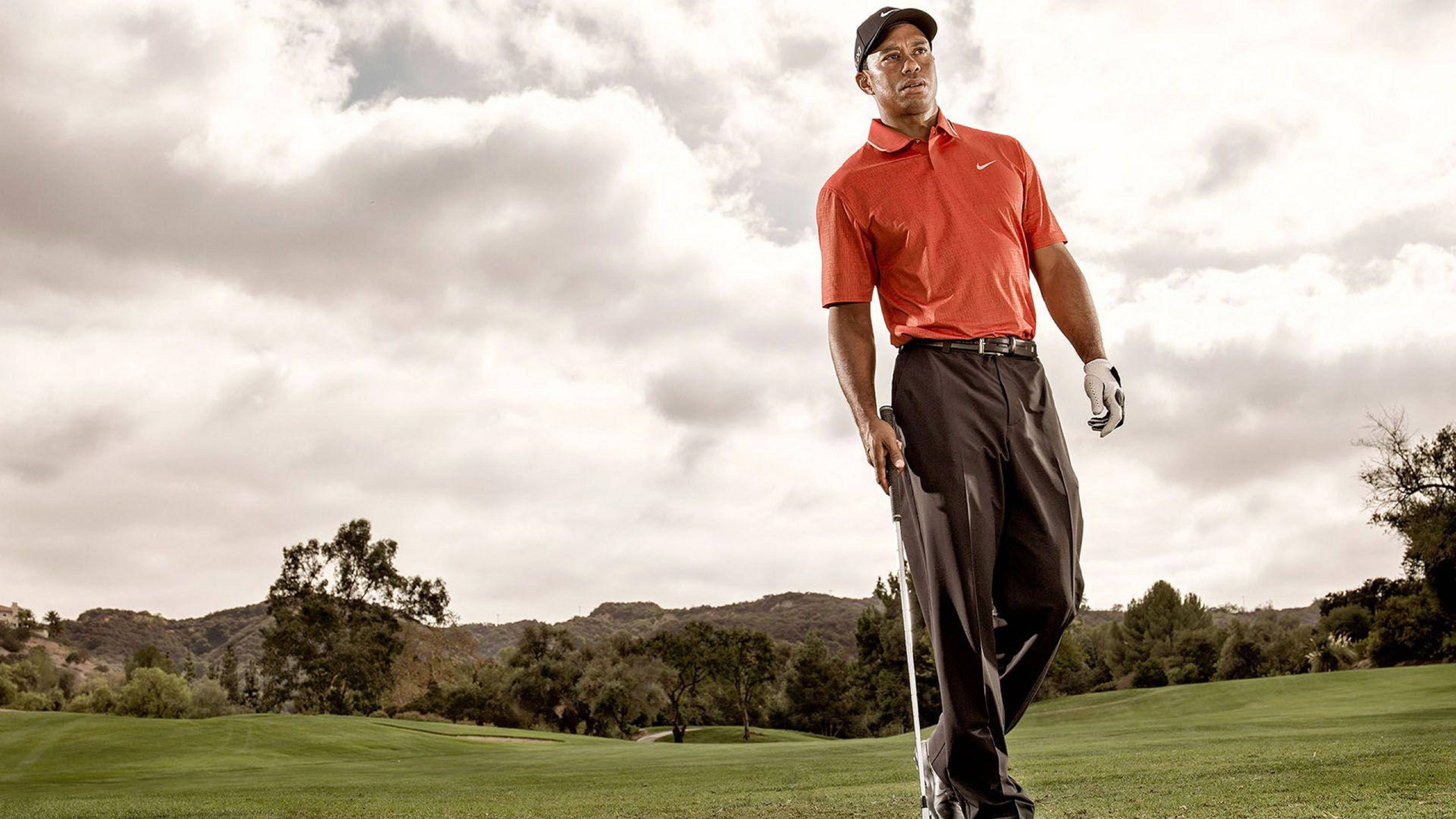 Tiger Woods 數位藝術 壁紙 — 老虎活士在戲劇性的多雲天空下自信地走過翠綠的高爾夫球場。