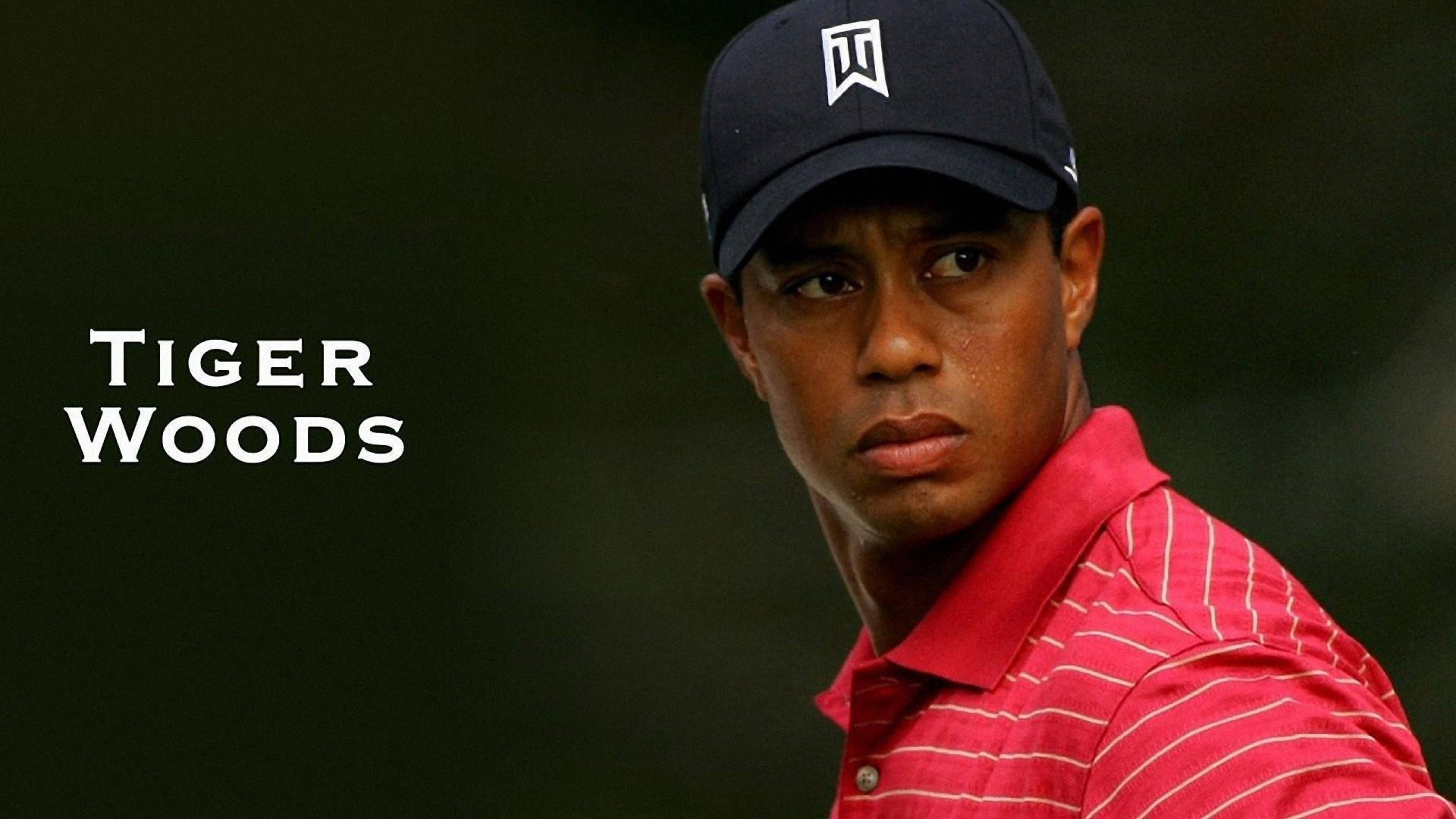 Tiger Woods 肖像畫 壁紙 — 老虎活士穿著紅色條紋Polo衫和海軍藍帽子，在黑暗模糊的背景前專注地凝視。