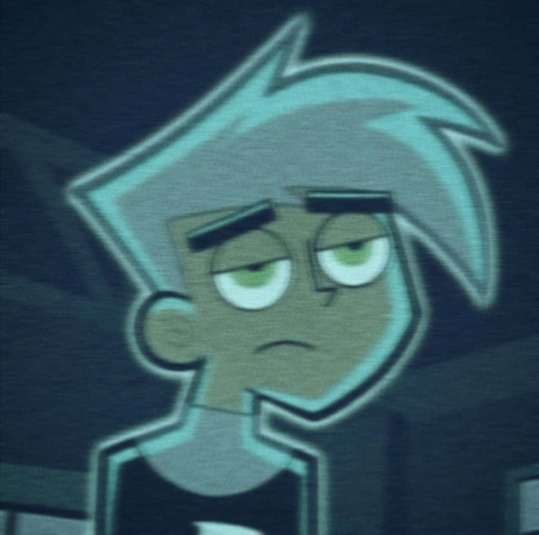 TikTok 用的可愛 Danny Phantom 頭像 壁紙 — 一個卡通角色，有著尖刺的灰色頭髮和綠色眼睛，在黑暗背景下顯得很惱火。