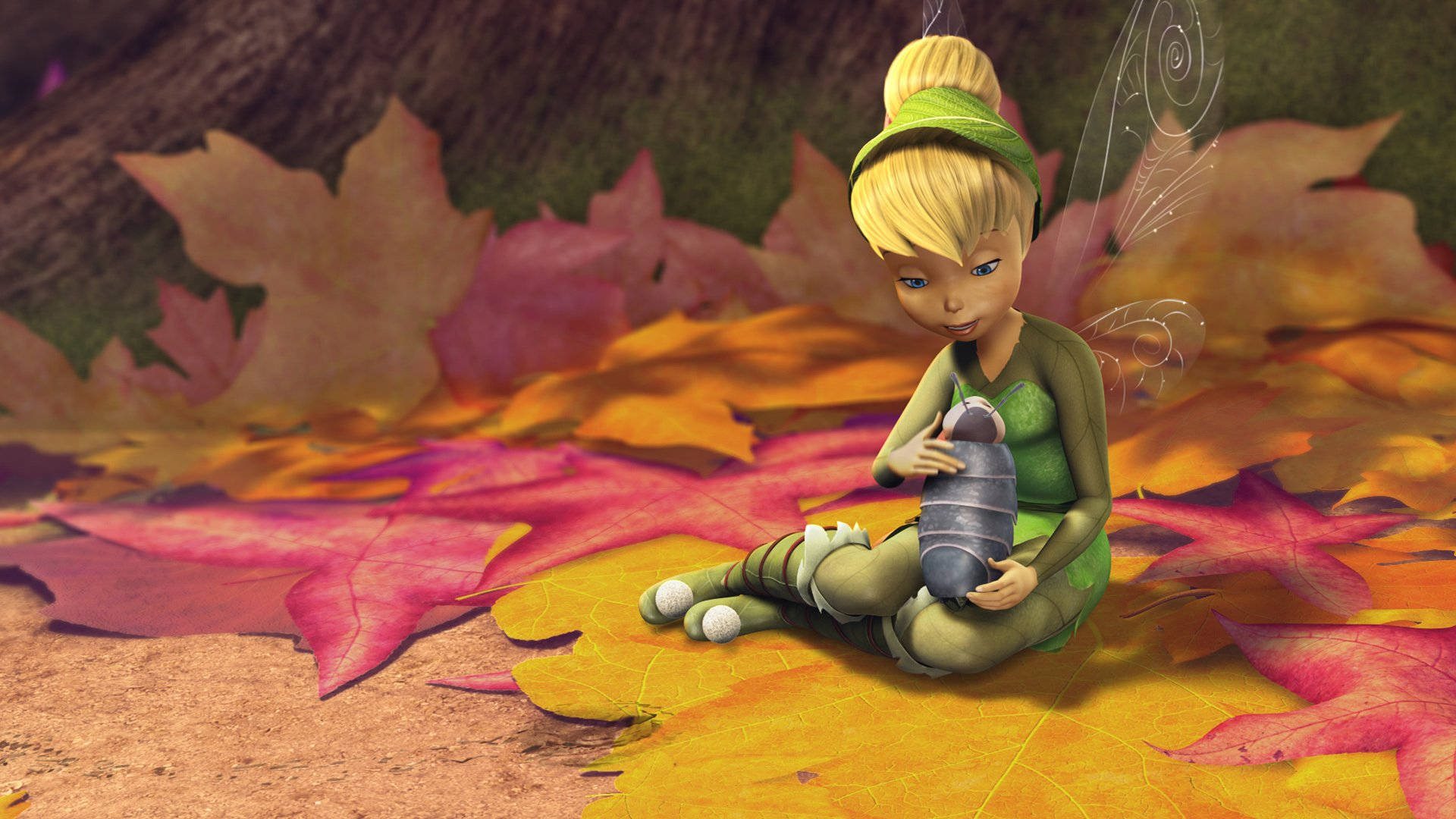 tinkerbell 躺在葉子上 壁紙 — 一個穿著綠色衣服、金髮的小仙子坐在鮮豔的秋葉中，懷抱著一個熟睡的小生物。