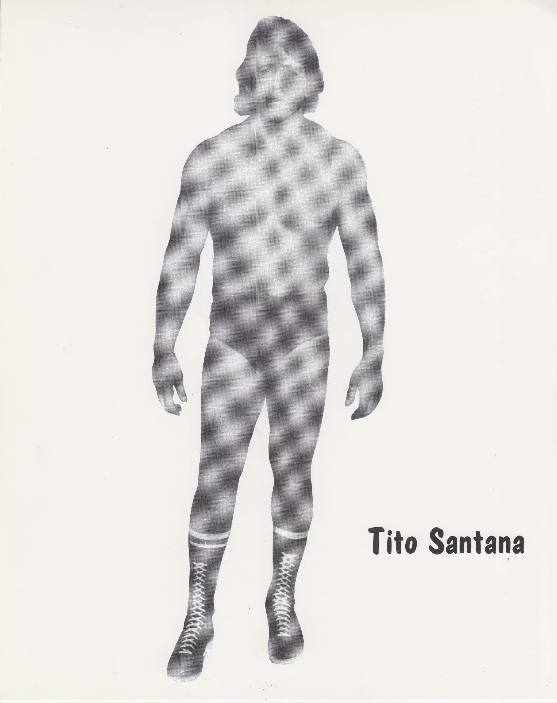 Tito Santana 古早黑白照片 壁紙 — 摔角手Tito Santana身穿摔角短褲和靴子，全身站立的黑白工作室肖像。