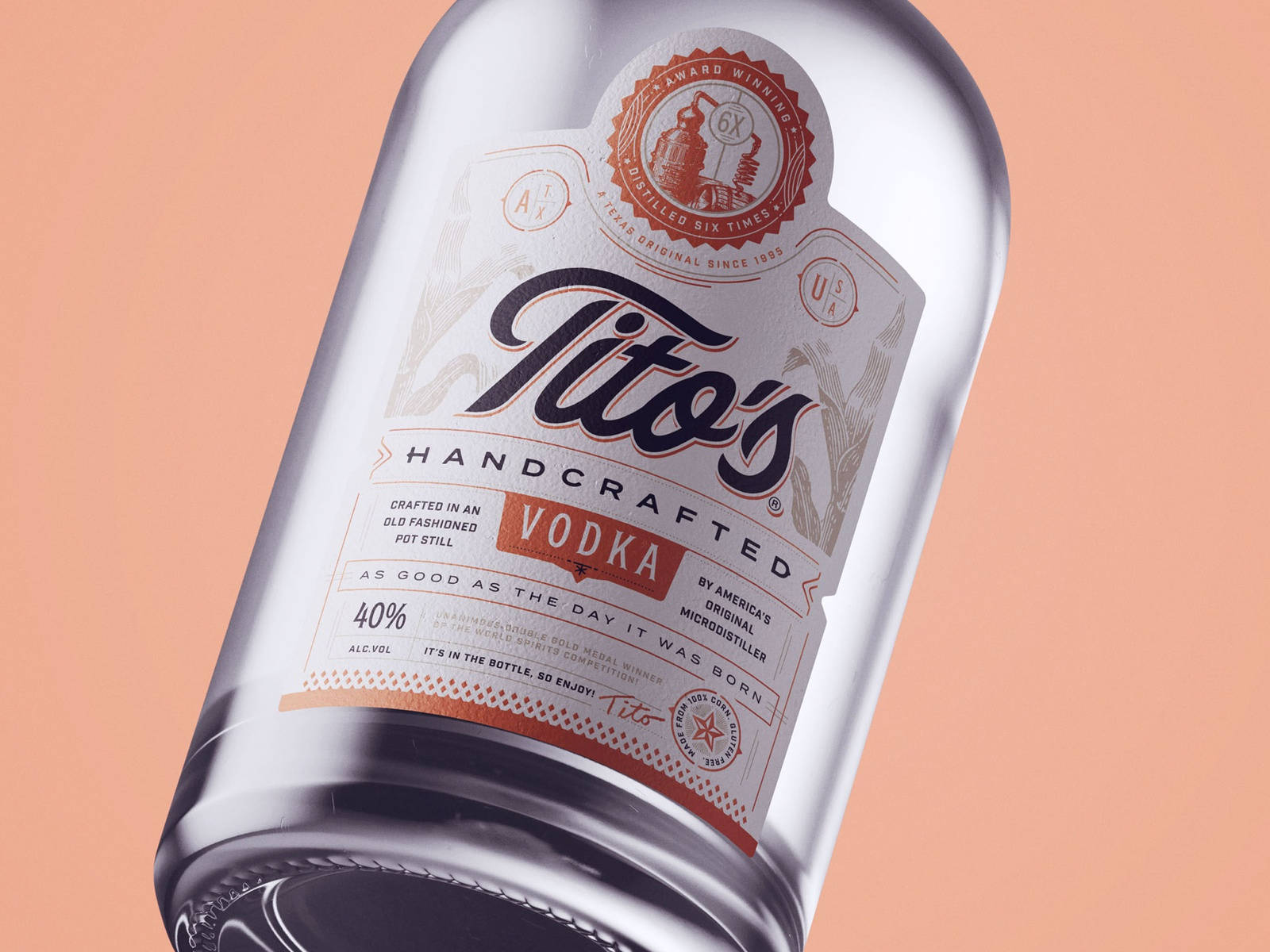 Tito's Handcrafted Vodka酒瓶，標籤細節在蜜桃色背景上