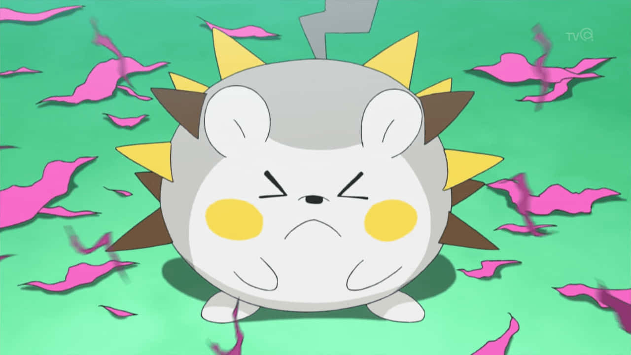 Togedemaru 展示三角形刺 壁紙 — 一個圓形灰色動畫寵物小精靈，有黃色臉頰和尖刺的棕色和黃色頭髮，在綠色背景上漂浮的粉紅色花瓣中看起來很生氣。