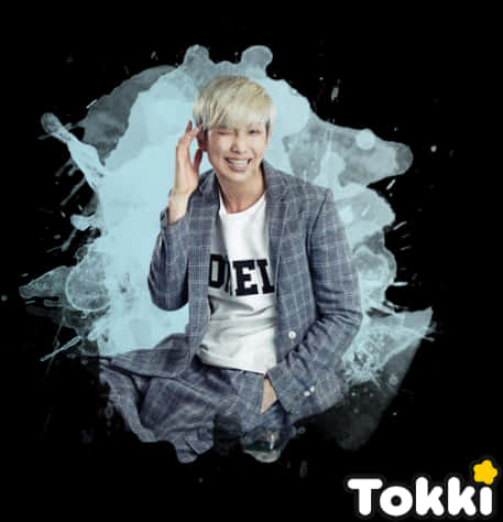Tokki BTS成員藝術背景 壁紙 — 一位微笑的金髮年輕男子穿著格紋西裝，坐在黑色背景上動態的藍色潑濺前。