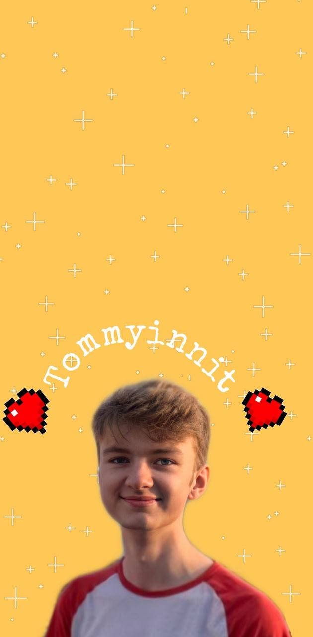 Tommyinnit黃色背景 壁紙 — 一位微笑的年輕男子穿著紅白相間的襯衫，背景是明亮的黃色，帶有像素心形和加號。