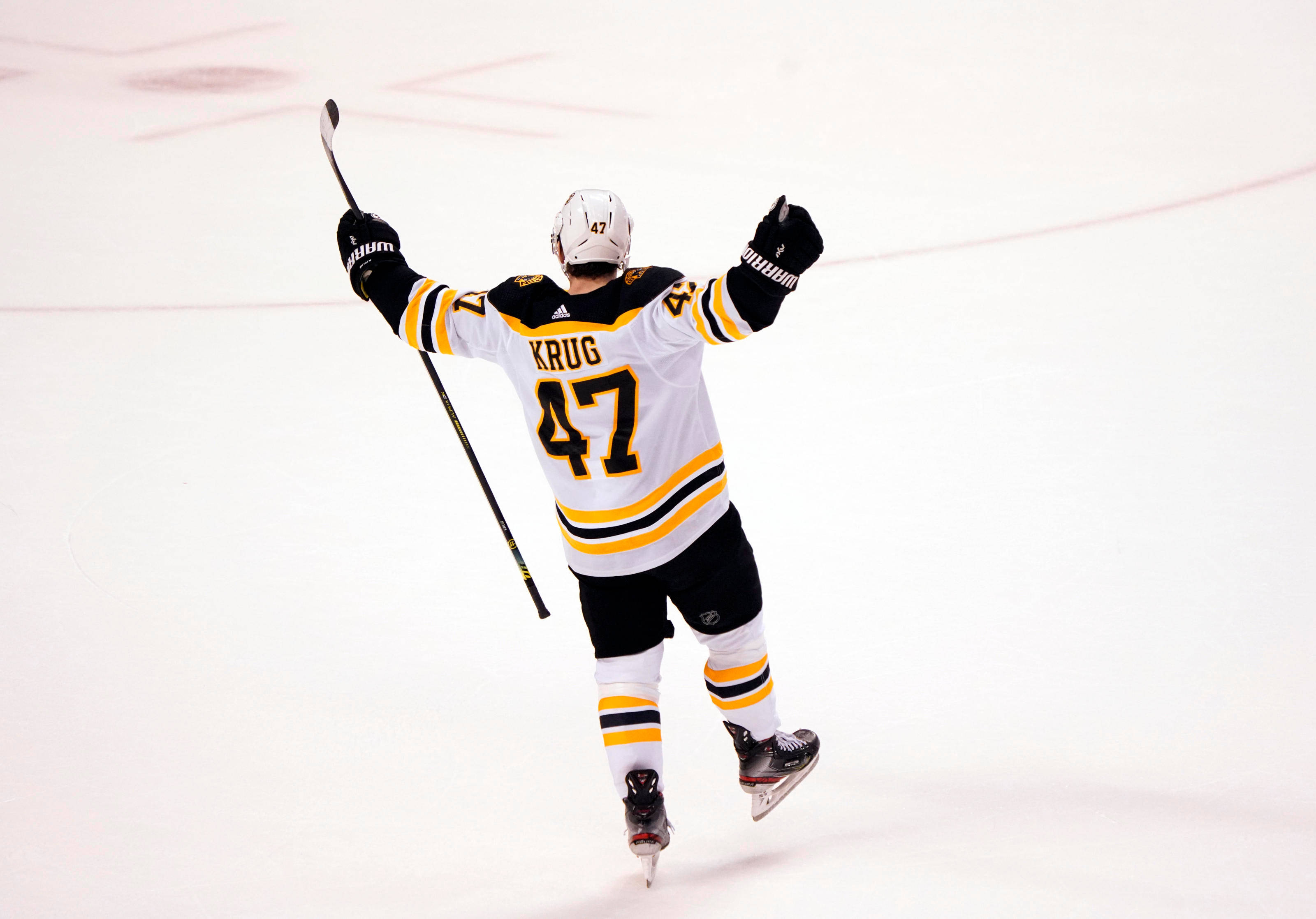 Torey Krug 慶祝制勝入球 壁紙 — 冰球運動員Krug 47號在比賽期間於冰場上舉臂慶祝。