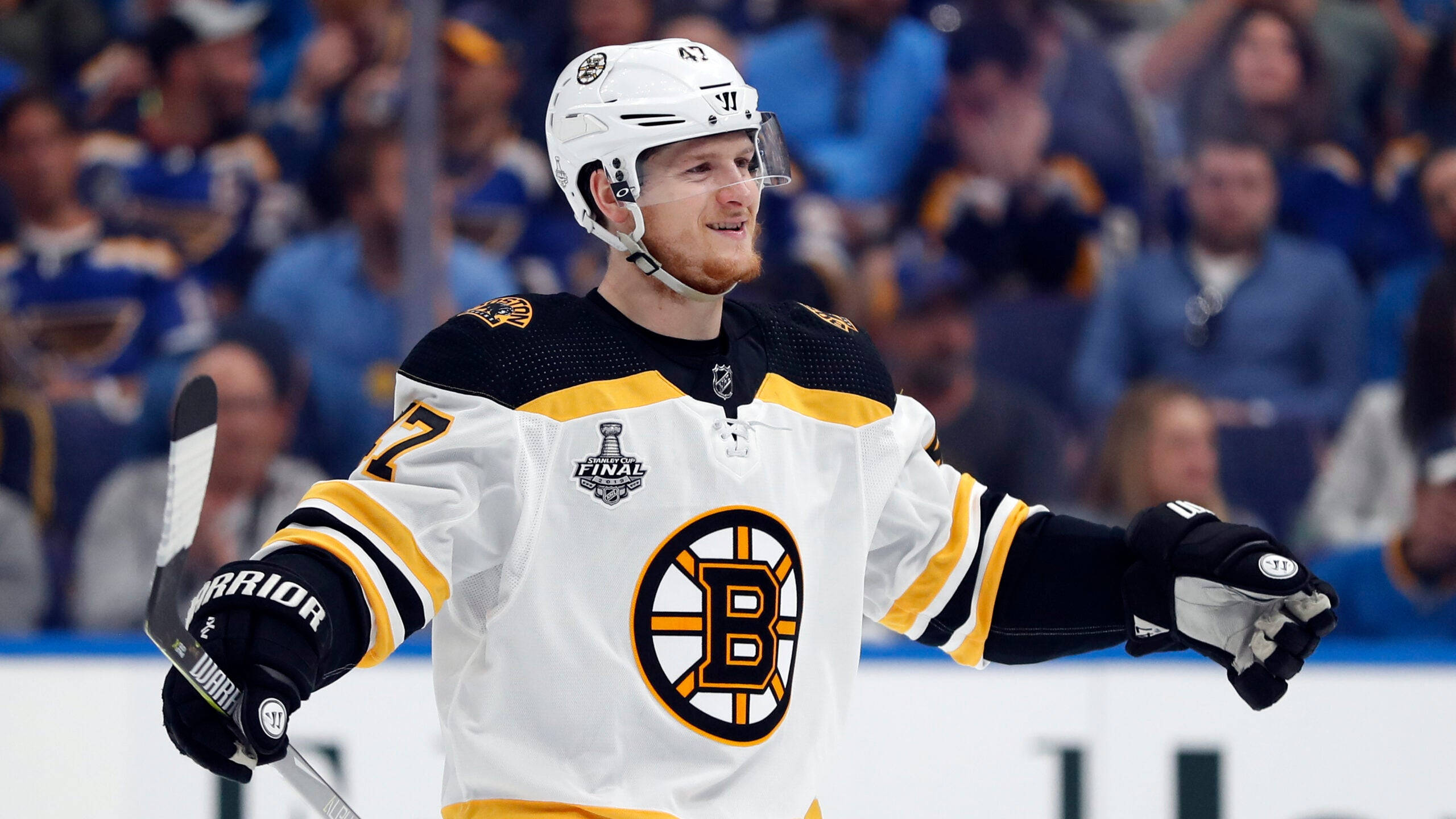 Torey Krug 慶祝精彩勝利 壁紙 — 一名身穿白色球衣的波士頓棕熊冰球球員在史丹利盃決賽中張開雙臂在冰上慶祝。