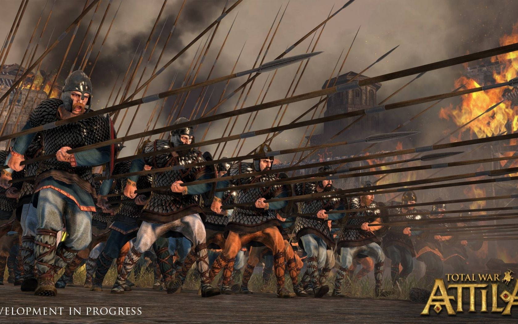 Total War: Attila 長矛衝鋒戰士 壁紙 — 一幅數碼藝術描繪，身穿盔甲的戰士在煙霧瀰漫的天空下，於燃燒的戰場上持矛衝鋒。