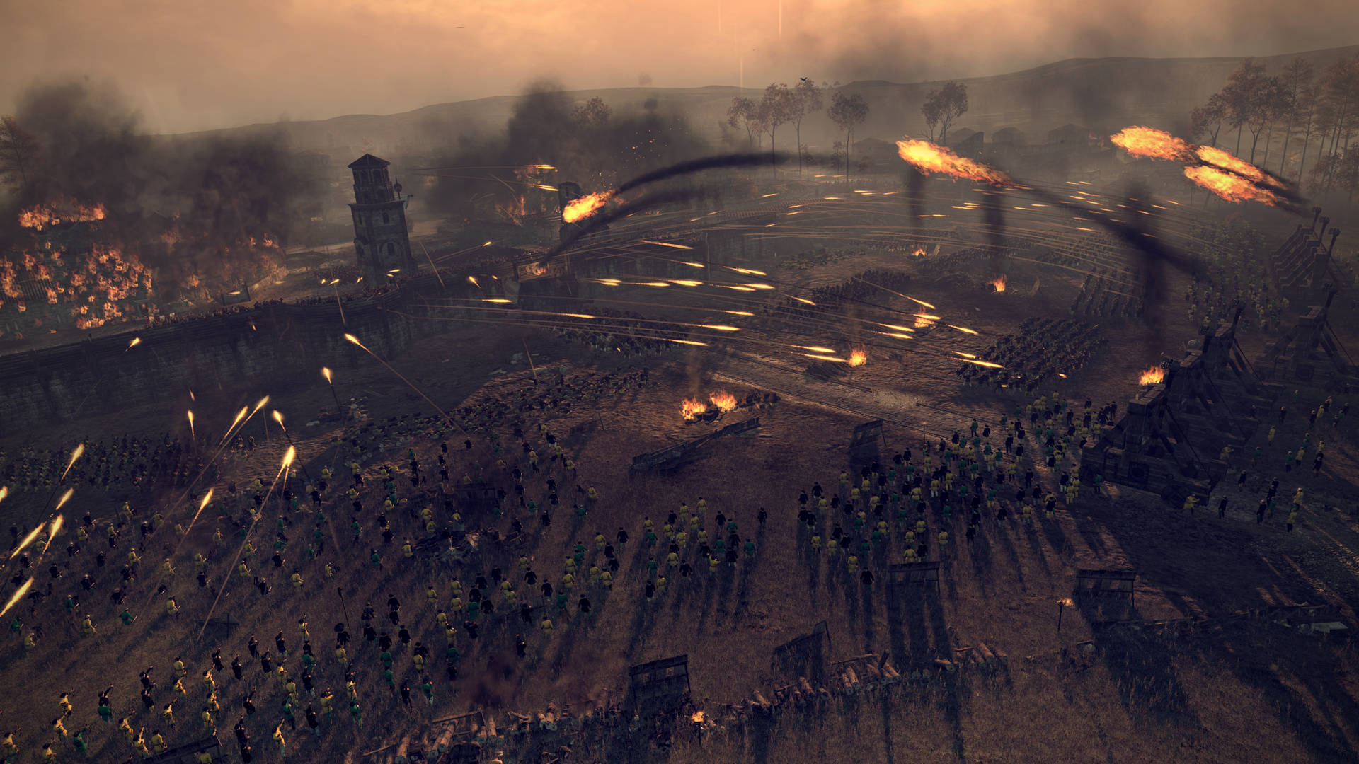 Total War：阿提拉 超級征服戰役 壁紙 — 黃昏時分的大規模戰場，在煙霧瀰漫的橙色天空下，軍隊在燃燒的建築物和飛行的投射物中激烈交戰。