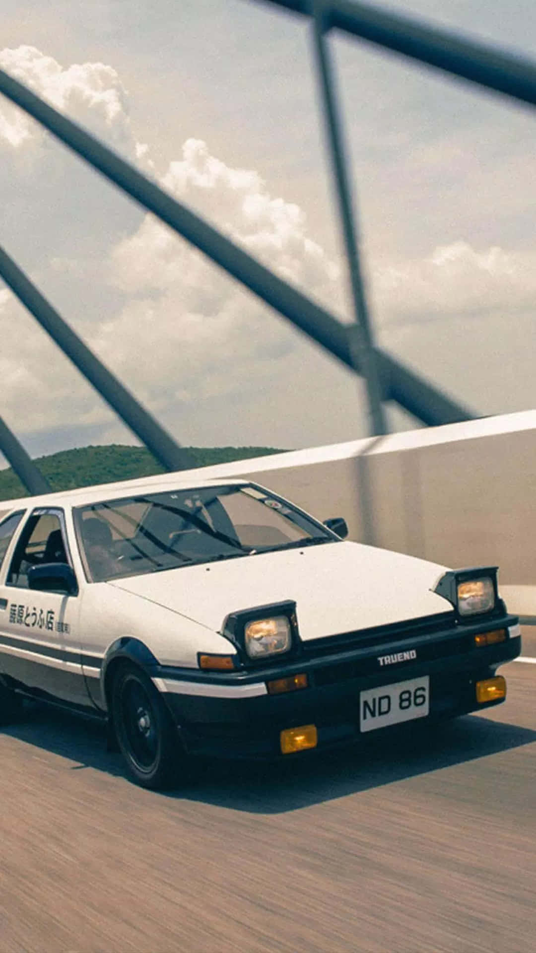 白色AE86跑車在橋上飄移，天空多雲，有欄杆。