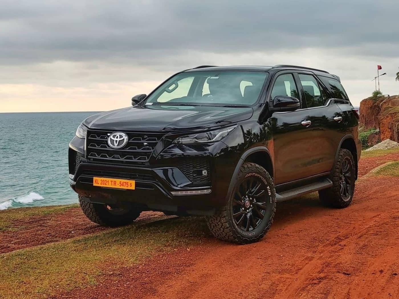 黑色豐田 SUV 停泊在海邊紅土懸崖上