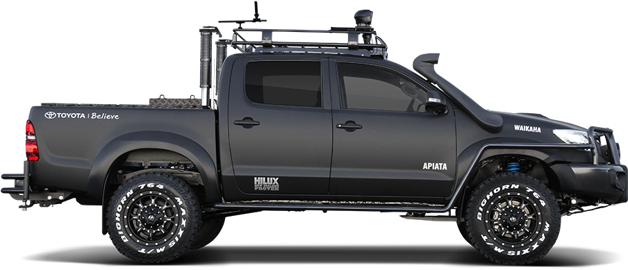 Toyota Hilux皮卡側面視圖 壁紙 — 一輛啞光黑色的豐田 Hilux 皮卡車，配備堅固輪胎和車頂行李架，孤立在純黑色背景前。