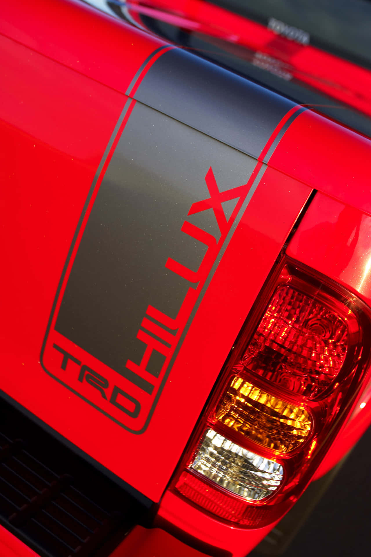 紅色豐田 Hilux TRD 貨車車尾，帶有黑色條紋和發光尾燈。
