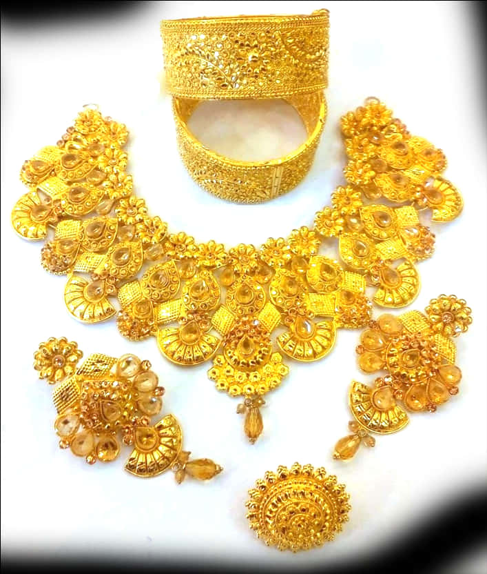 Traditional Indian Gold Jewelry Set 壁紙 — 一套奢華的金色珠寶套裝，帶有精緻的鏤空工藝和琥珀寶石，擺放在白色表面上。