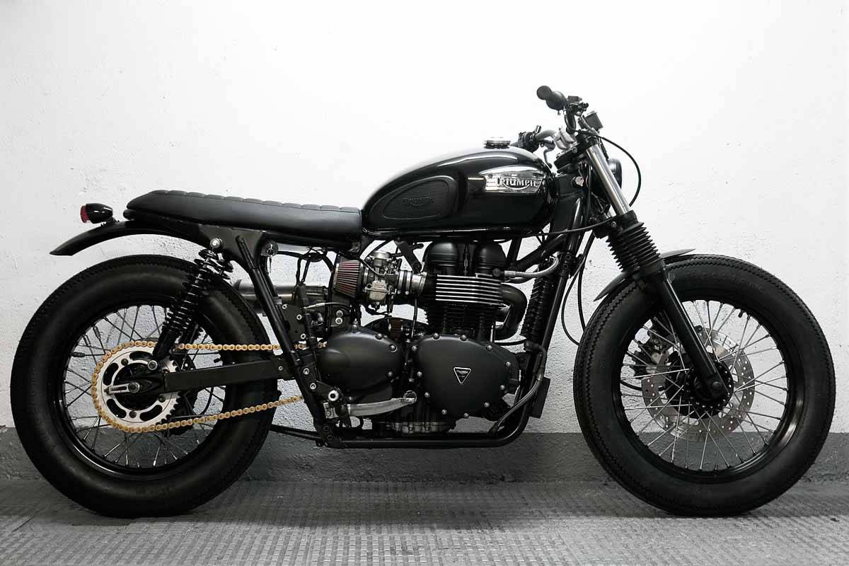 Triumph Bonneville 2007 黑色版 壁紙 — 一輛時尚的黑色Triumph電單車，帶有鍍鉻裝飾和厚輪胎，在紋理地板上對著白色牆壁擺好姿勢。