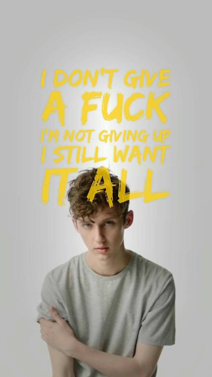 Troye Sivan《Fools》歌詞壁紙 壁紙 — 一個雙臂交叉的年輕男子在純灰色背景上，於粗體黃色文字下方（文字宣告反抗與渴望）強烈凝視鏡頭。