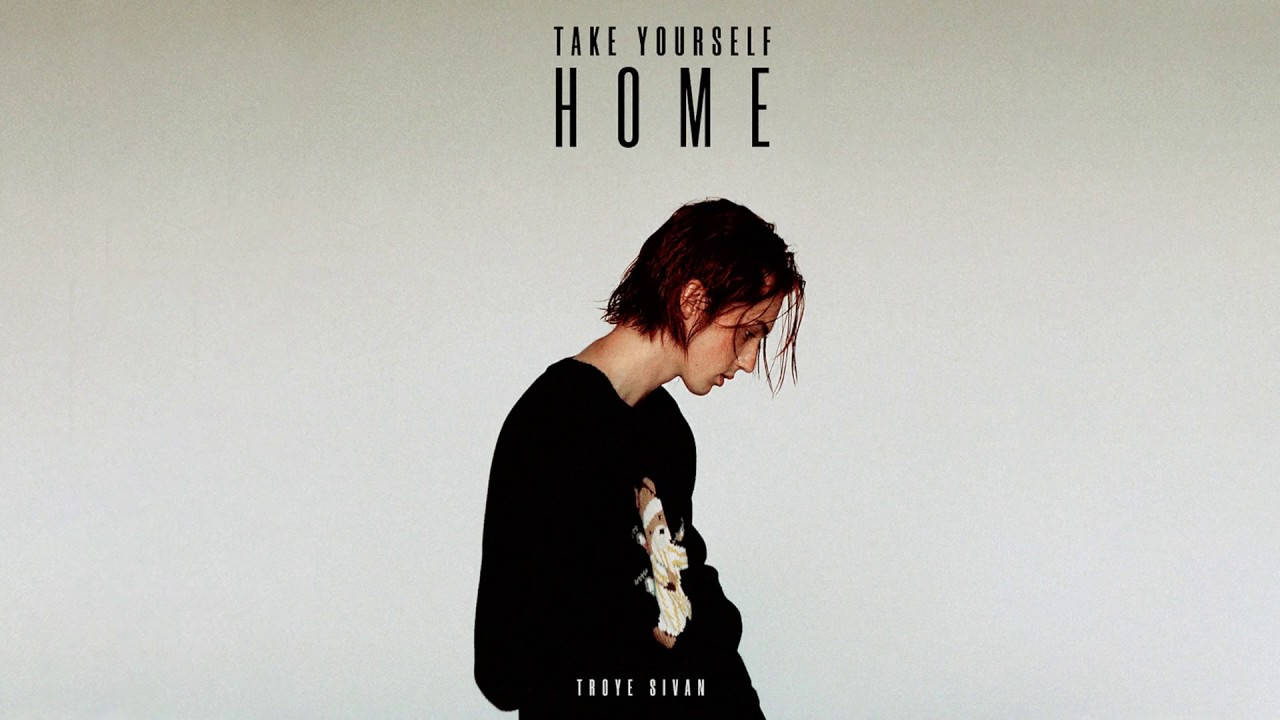 Troye Sivan《Take Yourself Home》專輯封面 壁紙 — 一個濕頭髮、穿黑色恤衫的人靠著素色牆，牆上方有文字 'TAKE YOURSELF HOME'。