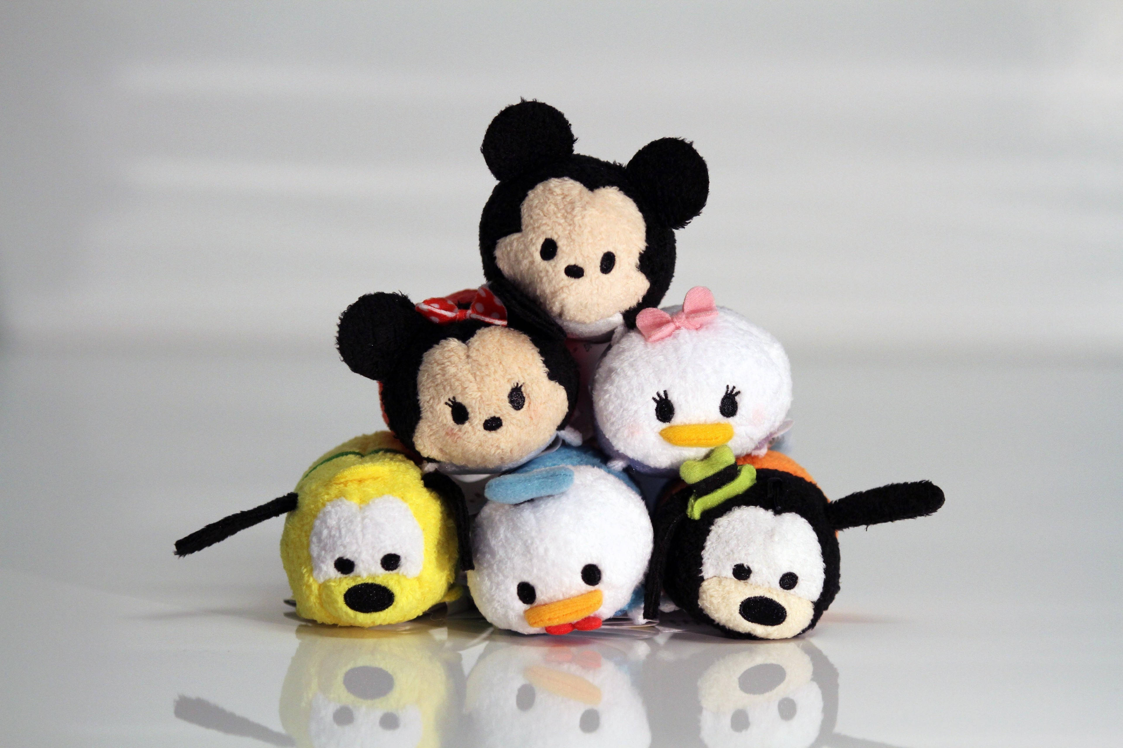Tsum Tsum 米奇老鼠 壁紙 — 六個迪士尼Tsum Tsum毛絨角色在柔和的攝影棚燈光下堆疊在反光的白色表面上。