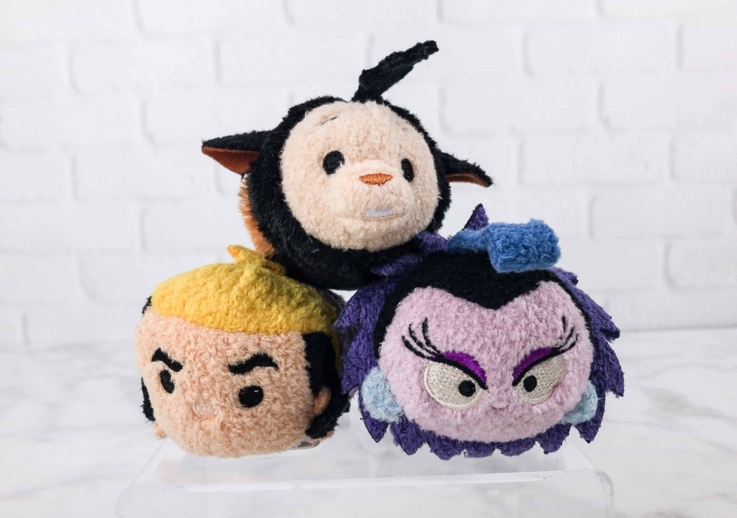 Tsum Tsum 羊駝三重奏 壁紙 — 三個毛茸茸的迪士尼 Tsum Tsum 毛公仔，表情各異，坐在透明架上，背景是白色磚牆。