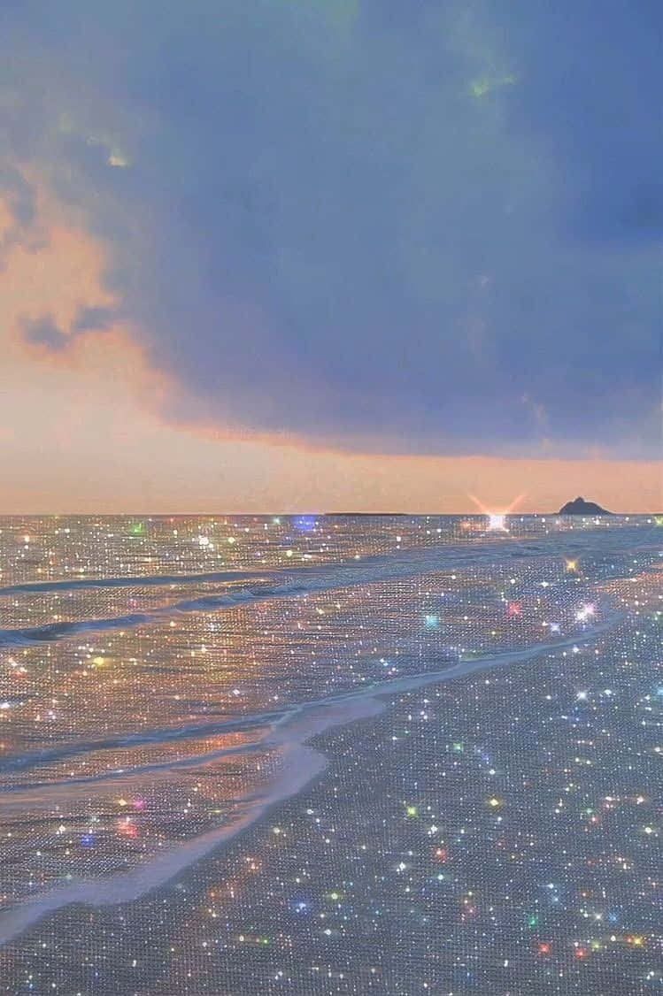 用這款亮片美學Tumblr靈感壁紙為生活增添一點閃耀 壁紙 — 日落時分閃閃發光的海灘，閃爍的海水和遠處的島嶼，在柔和粉彩的天空下。