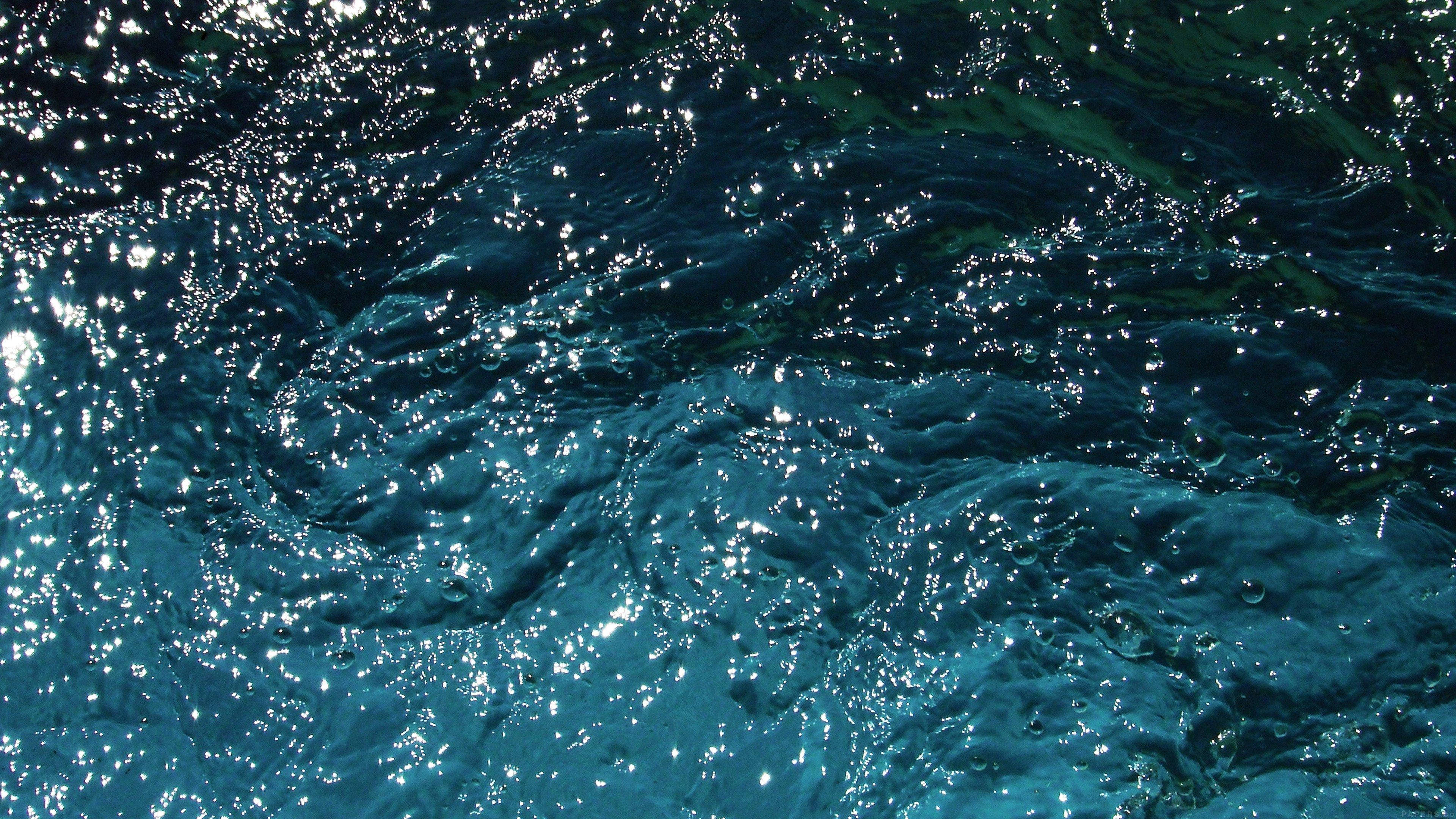 晶瑩藍色海水 Tumblr 壁紙 — 陽光在深藍綠色海浪上舞動，在紋理水面上形成閃爍亮點。