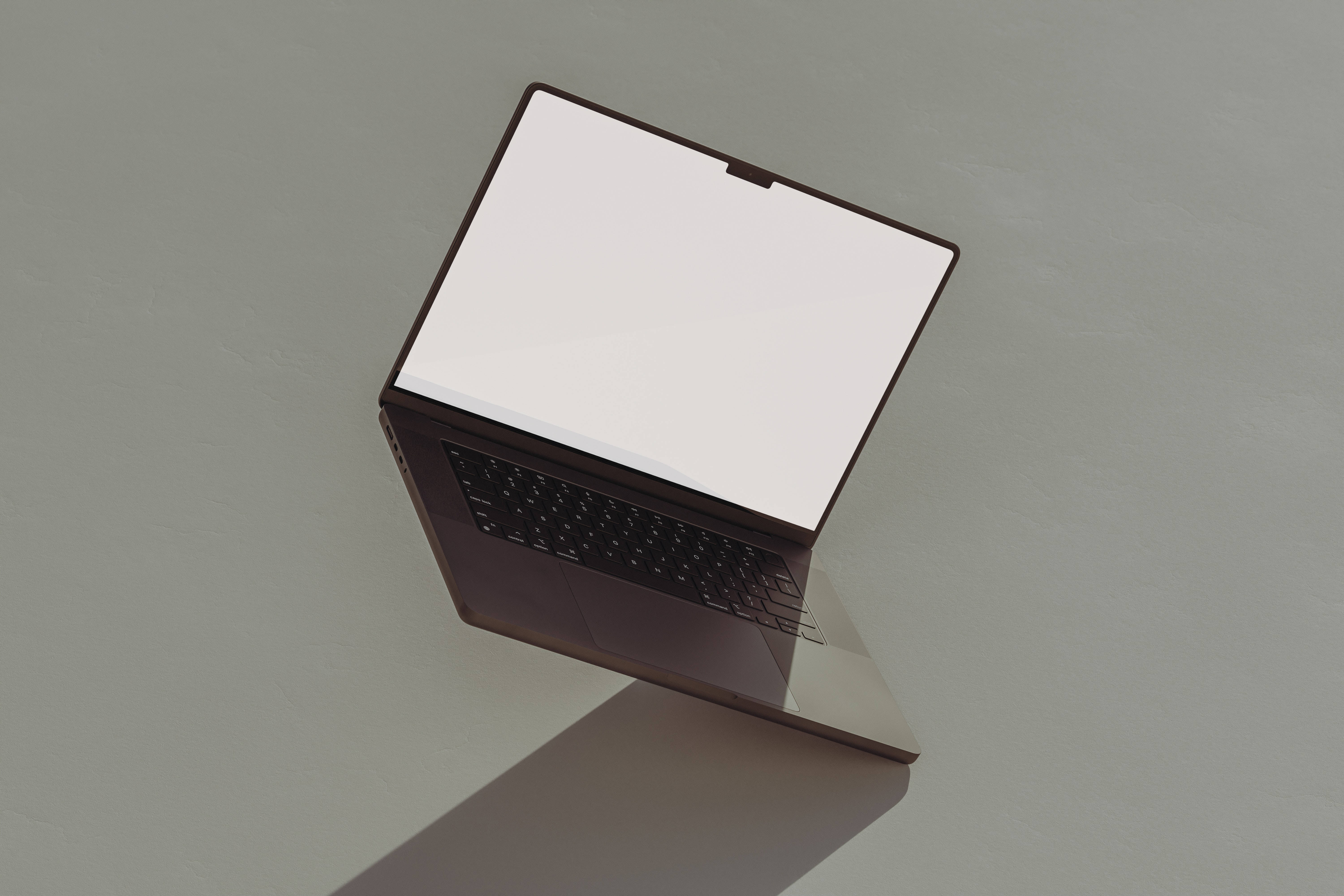 Tumblr風格傾斜筆電 壁紙 — 一部時尚的深色手提電腦，空白白色屏幕傾斜放置在極簡灰色表面上，投射出柔和陰影。