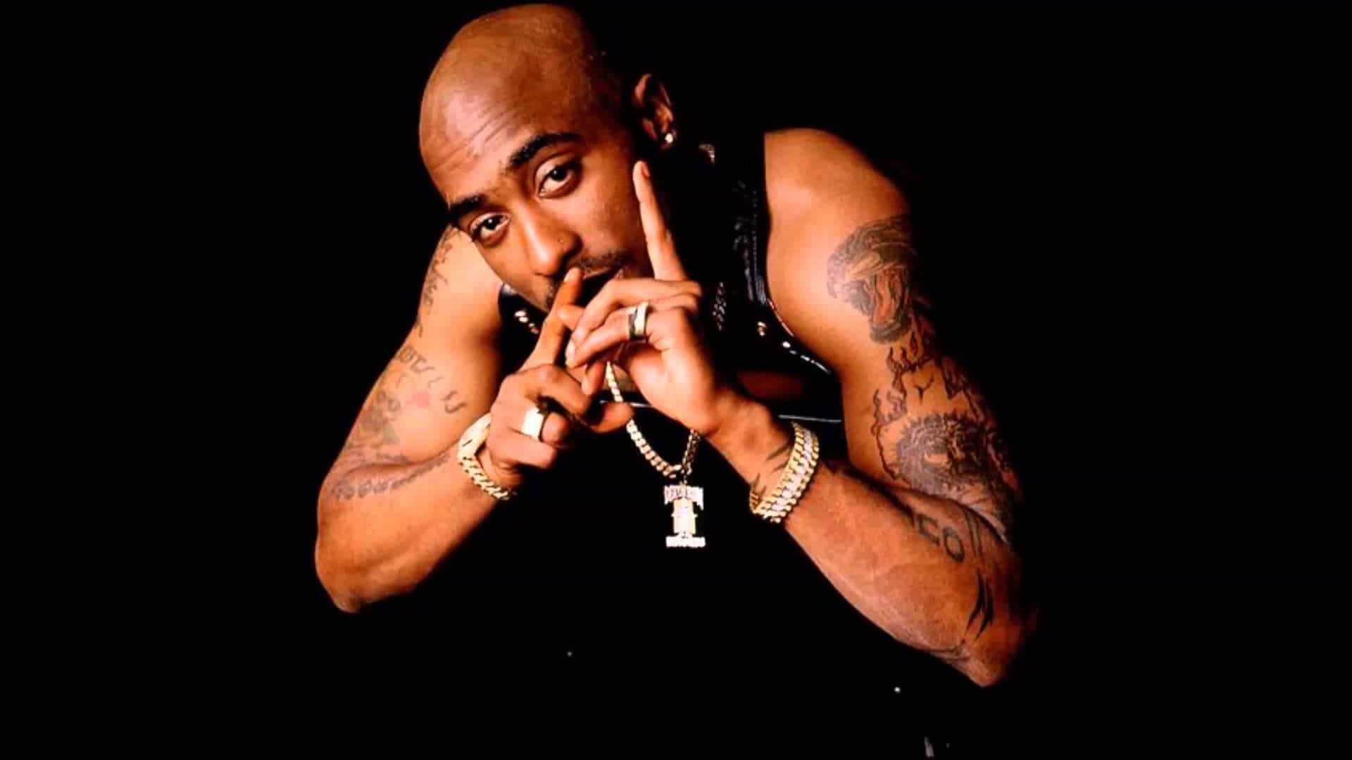 Tupac 桌布 壁紙 — Tupac Shakur 在黑色背景下帶有紋身和珠寶，強烈地擺姿勢。