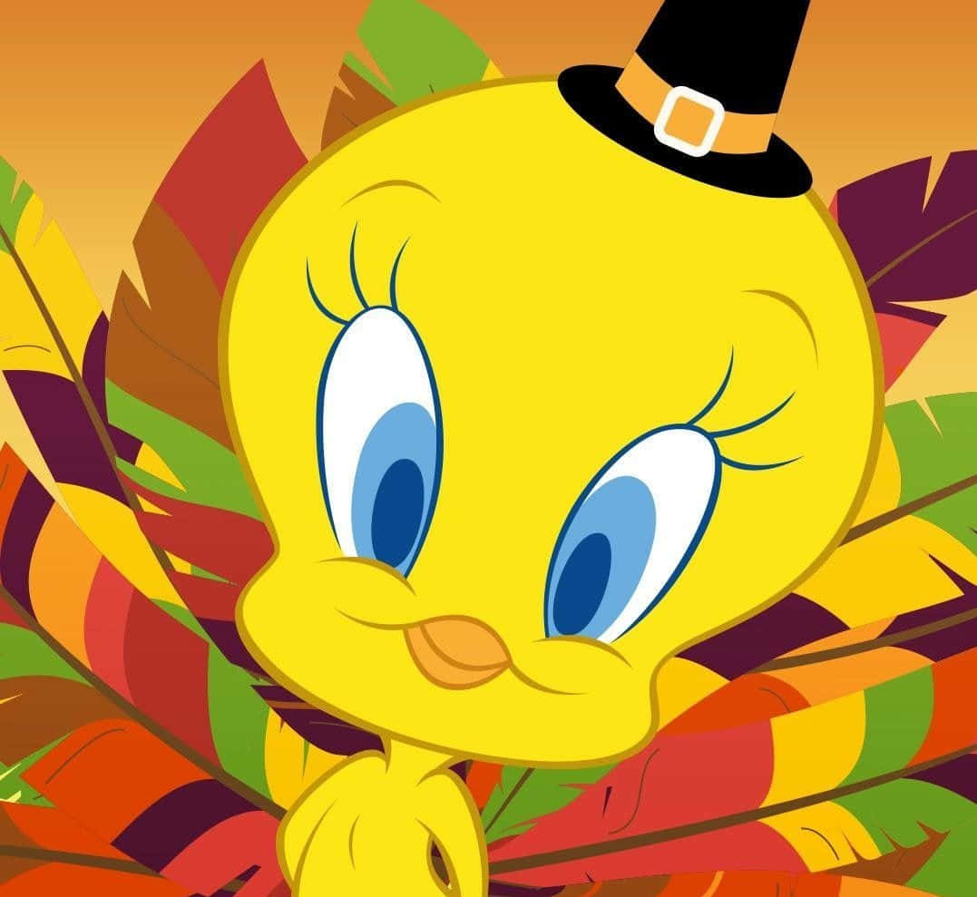 Tweety Bird走到哪裡都散播歡樂！ 壁紙 — 一隻戴著黑色朝聖者帽的快樂黃色卡通鳥，周圍環繞著色彩繽紛的秋葉。