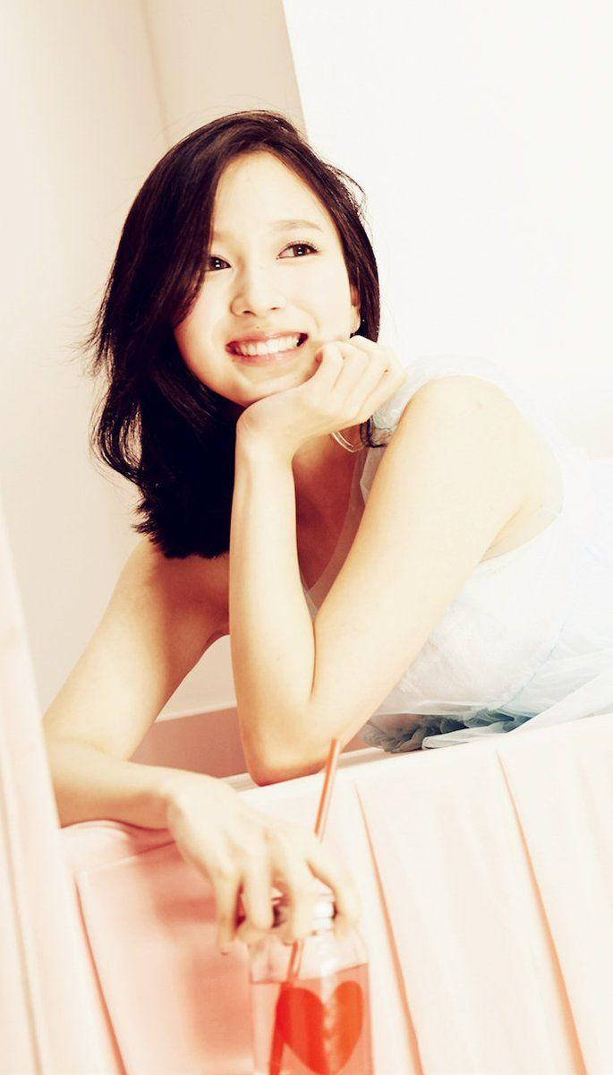 可愛 TWICE 成員 Mina 壁紙 — 一位深色頭髮的微笑女士，手托下巴，拿著一杯有心形冰塊的飲品。
