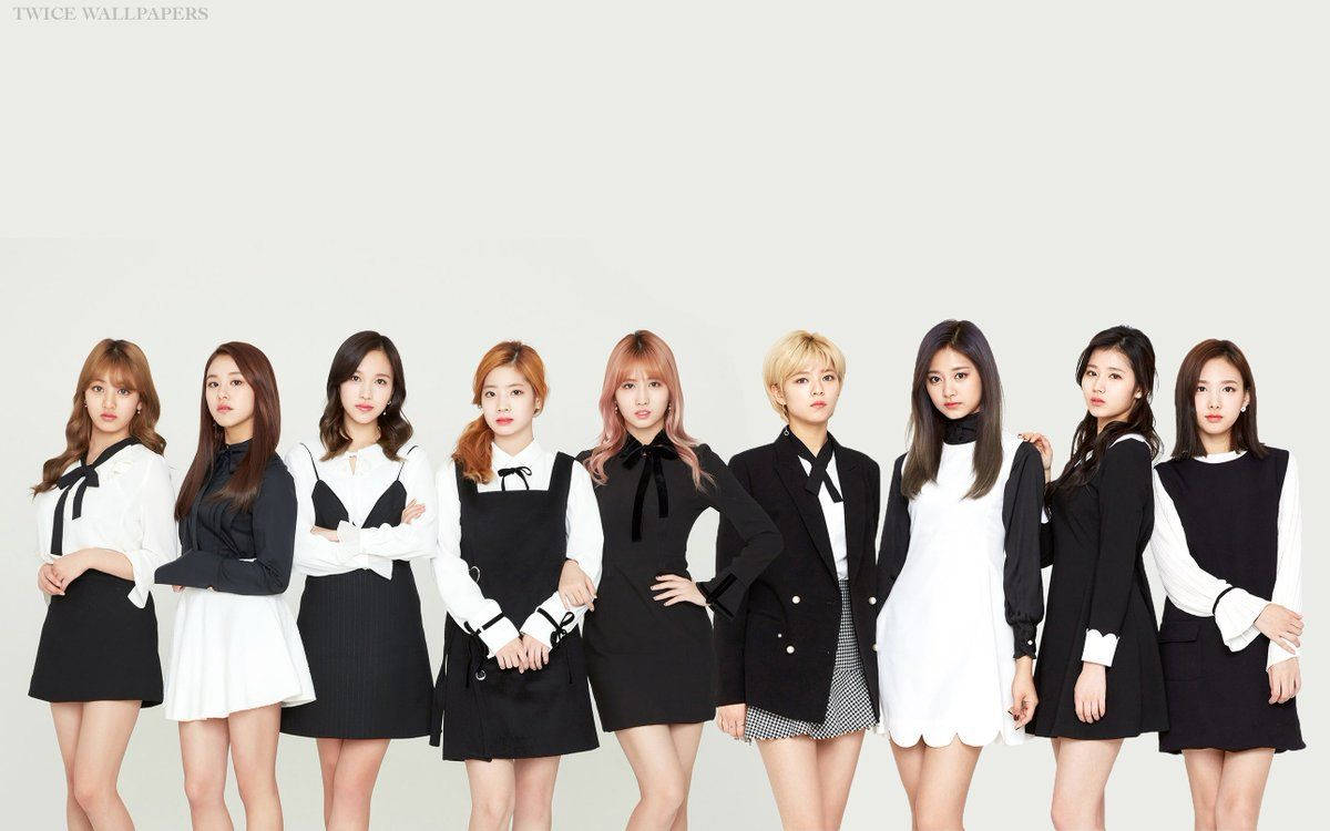 九位K-pop偶像穿著黑白服裝為攝影棚照片擺姿勢。