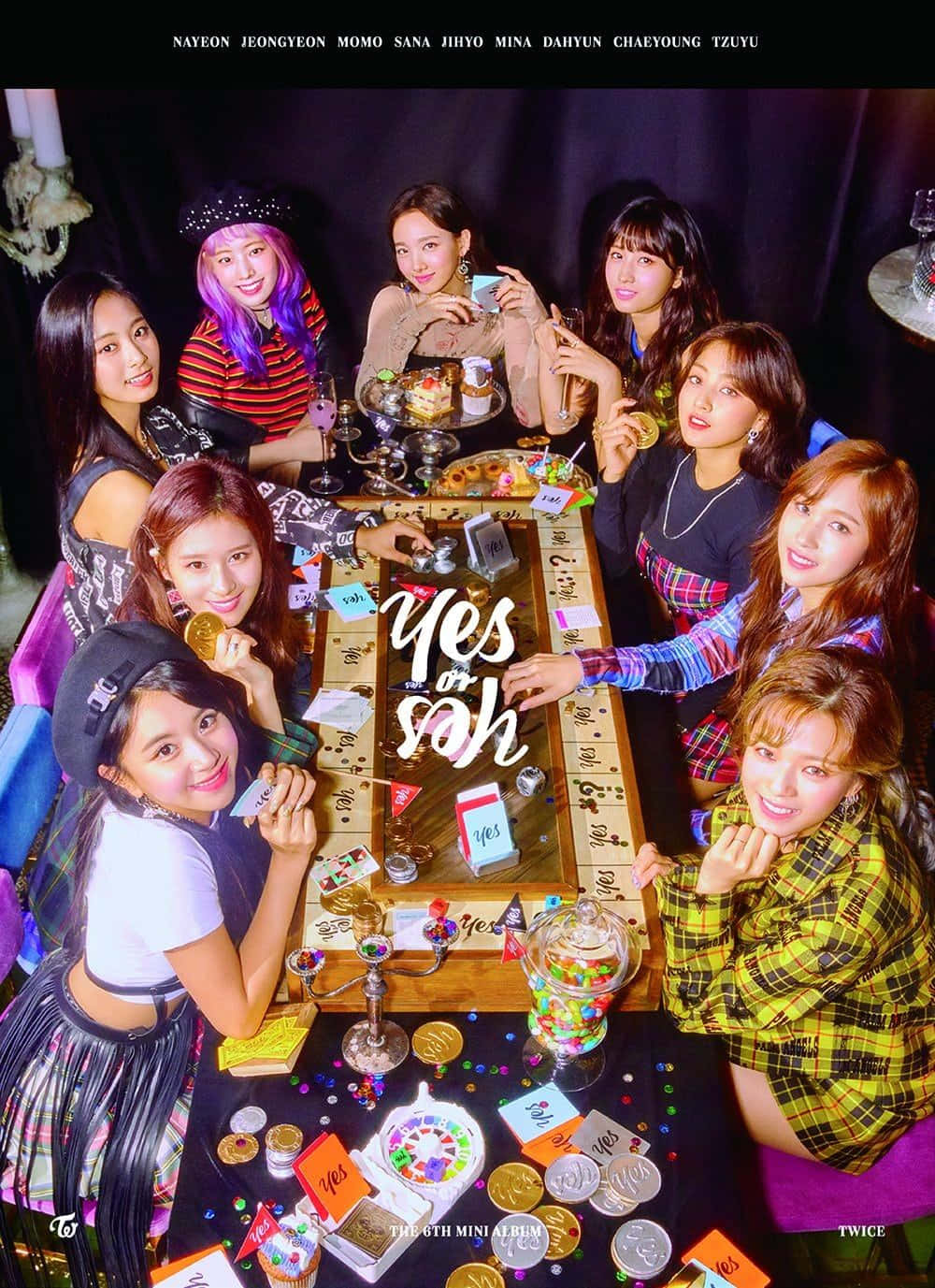 TWICE女子團體在音樂演唱會上閃耀登台 壁紙 — 九位身穿色彩繽紛服裝的女性在昏暗的攝影棚中圍繞著一張放滿硬幣、紙牌和糖果的遊戲桌。