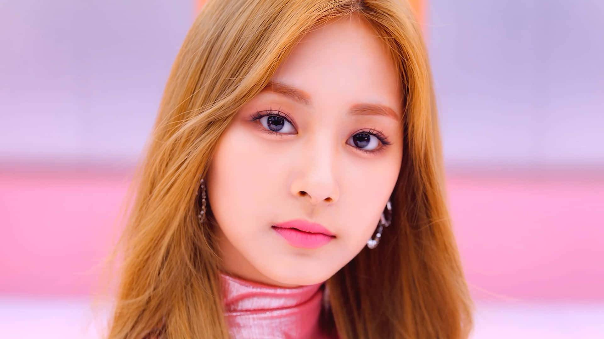 TWICE舞台上的熱情演出 壁紙 — 一位年輕女性的特寫肖像，金色頭髮和粉紅色唇膏，背景是柔和的粉紅色和紫色漸變。