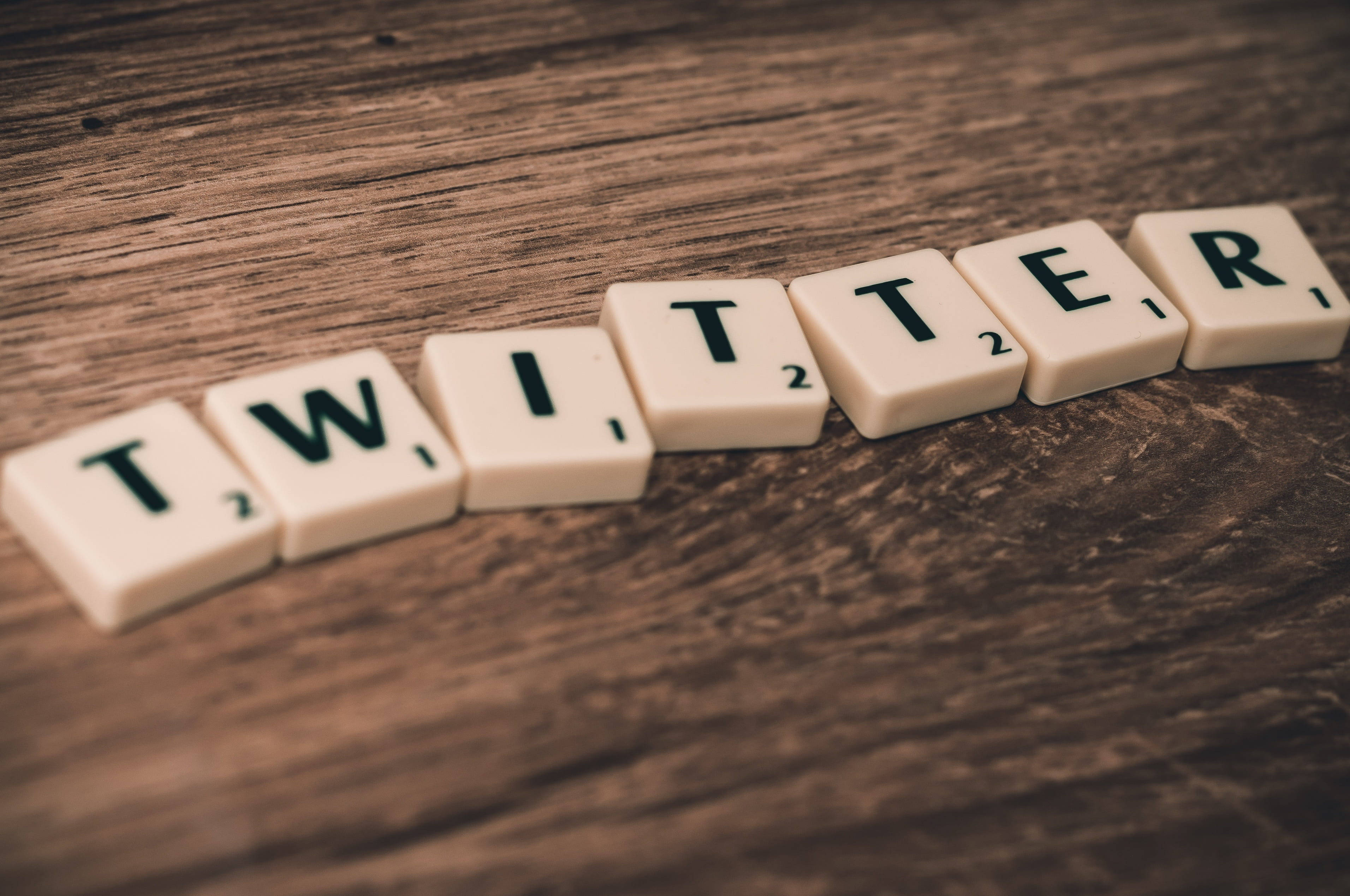Twitter 字母拼貼 壁紙 — 拼出 twitter 的 Scrabble 字母牌放在有紋理的木質表面上，景深較淺。