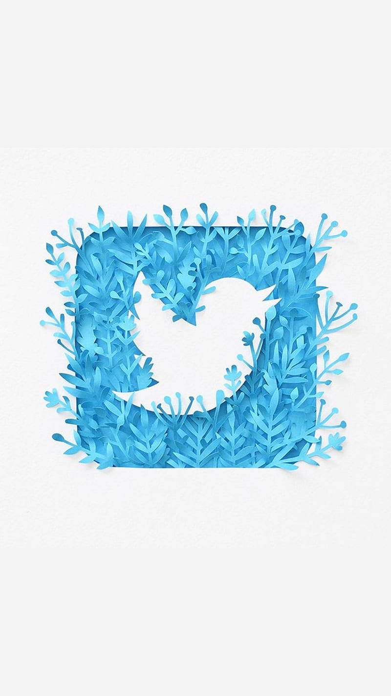 Twitter花卉風格標誌 壁紙 — 一個藍色紙雕Twitter鳥標誌，周圍環繞著層疊的樹葉，背景為白色。