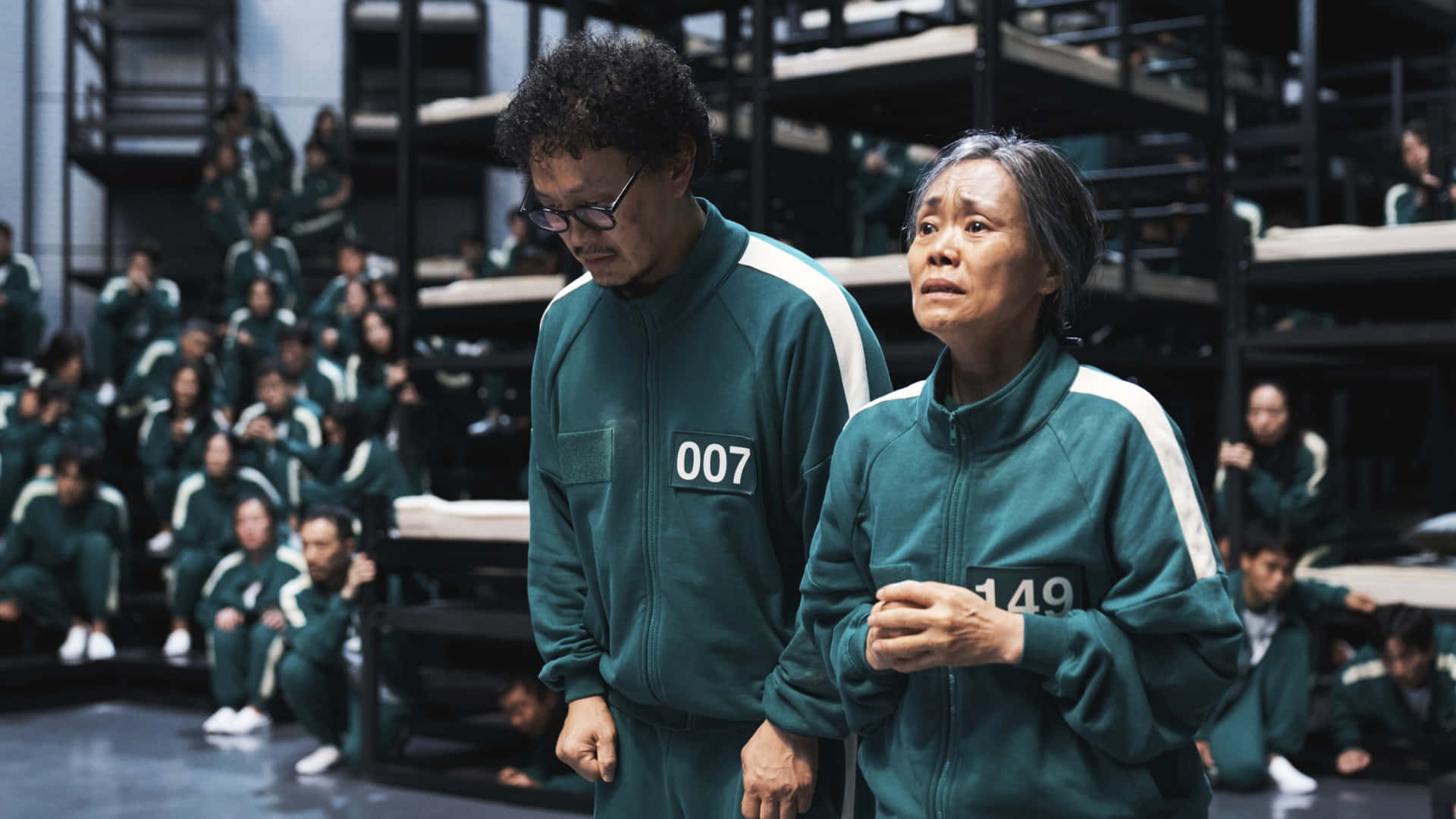  壁紙 — 兩名身穿綠色號碼運動服的參賽者站在一個簡陋的競技場中，周圍有其他玩家專注地觀看。