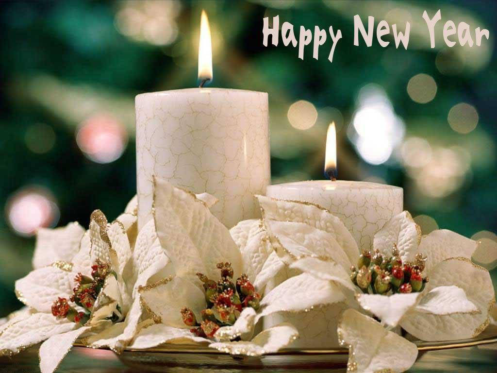 兩根點燃的蠟燭被白色聖誕紅和金色點綴環繞，用於新年慶祝。