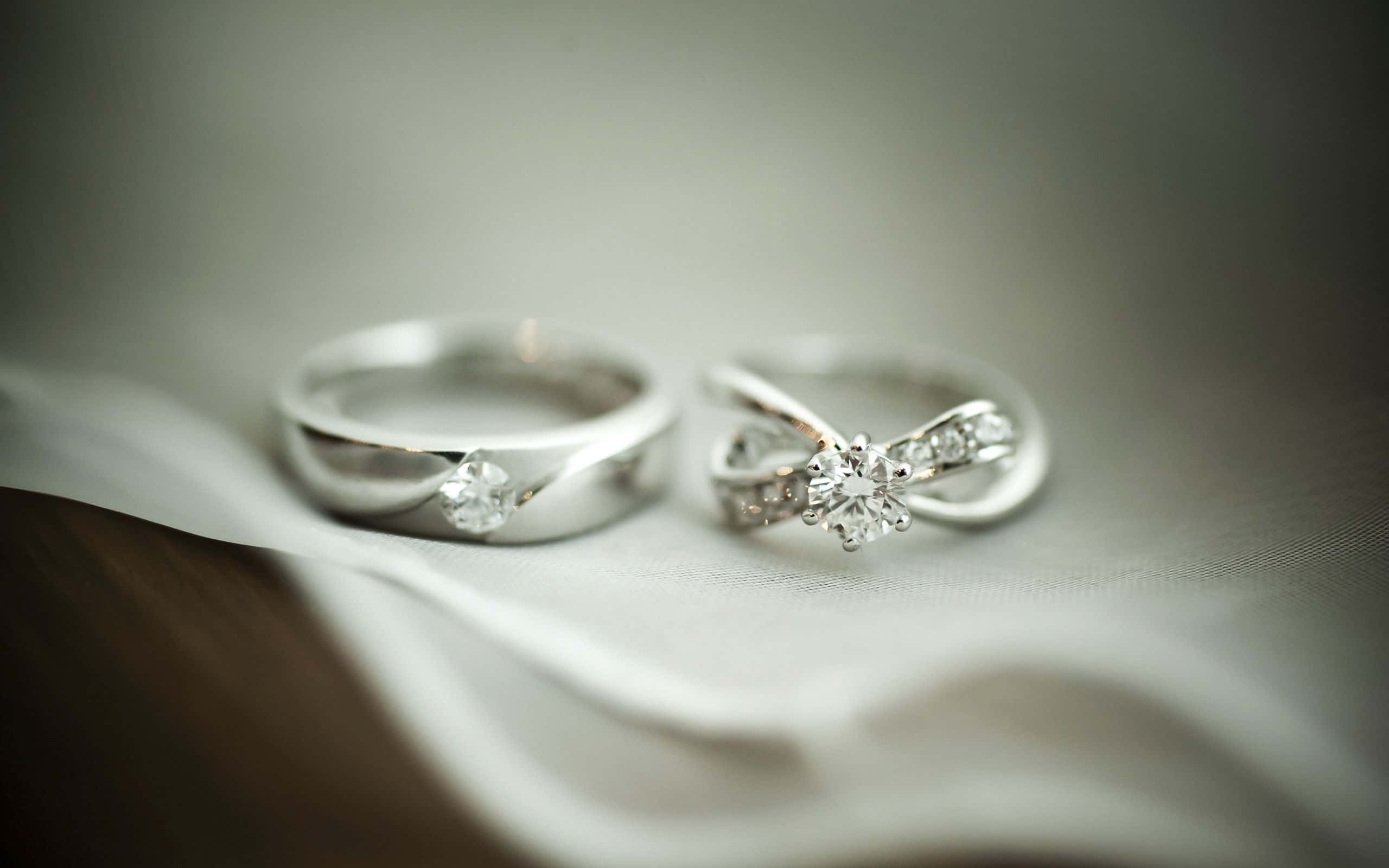 白色布料上的兩枚鑽石結婚戒指
