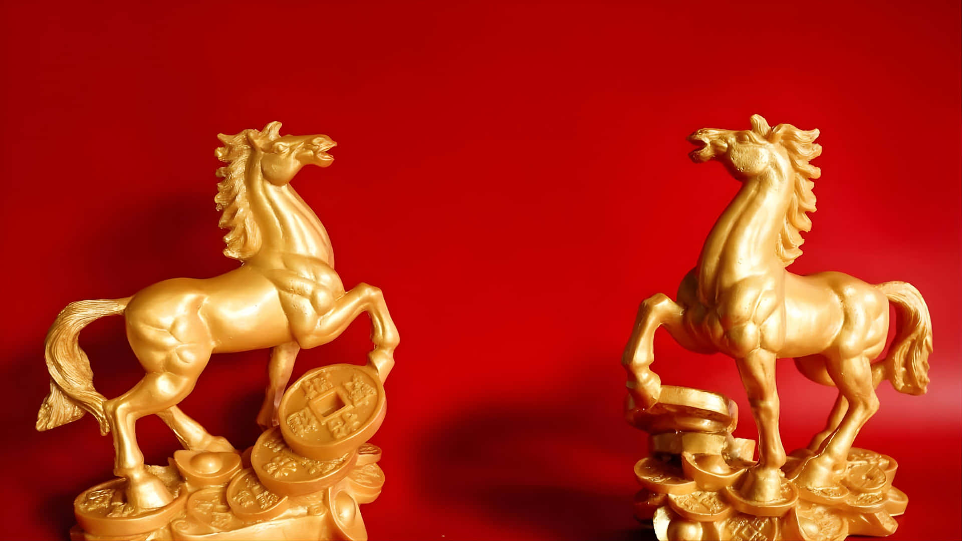  壁紙 — 兩尊閃閃發光的金色馬雕像傲然矗立在古代中國錢幣堆上，背景為大膽的紅色。